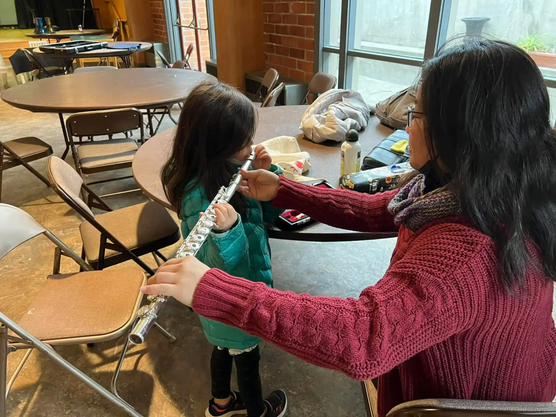 a woman helping a child with a toothbrush