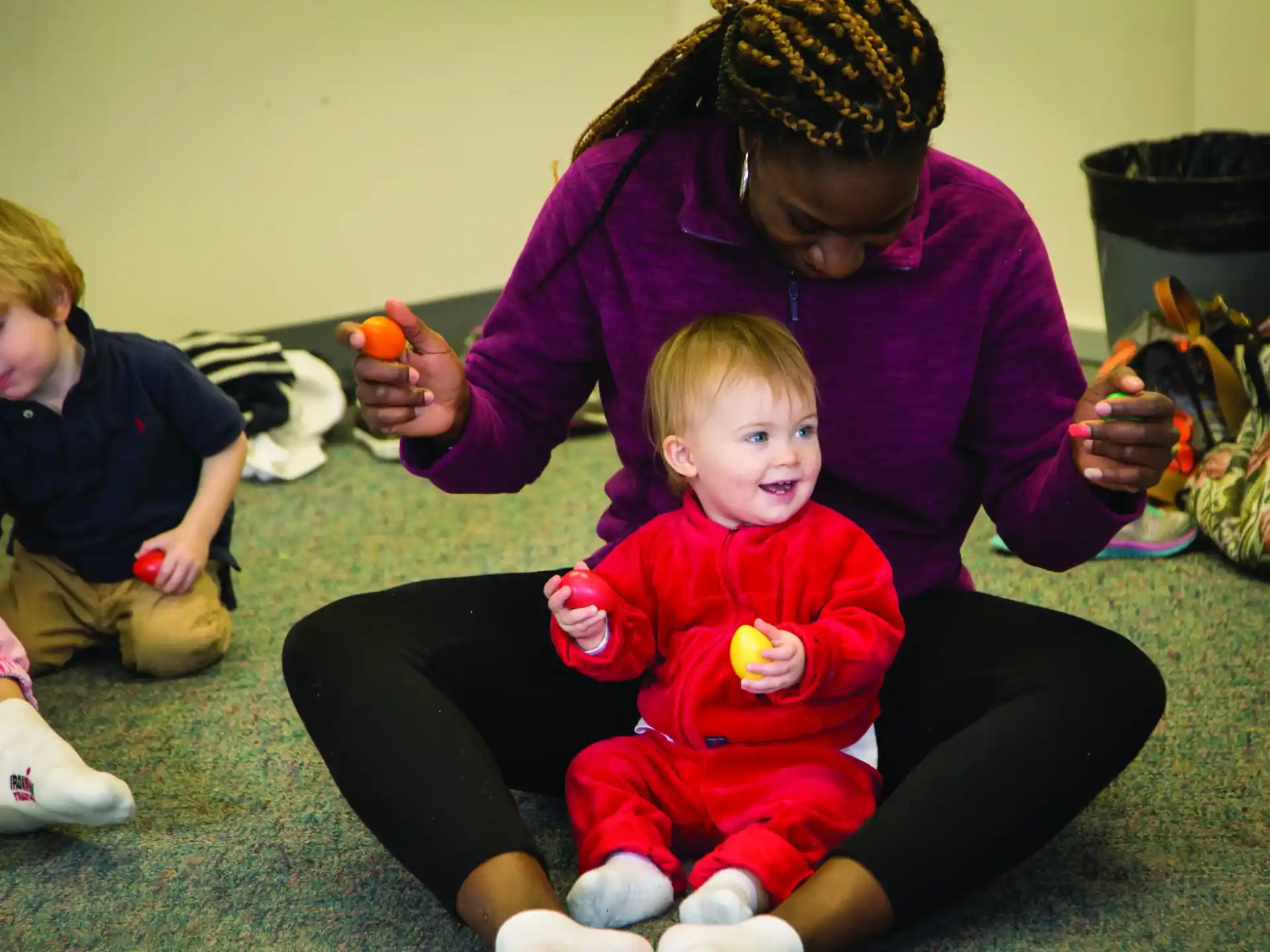 a person kneeling down to pet a baby