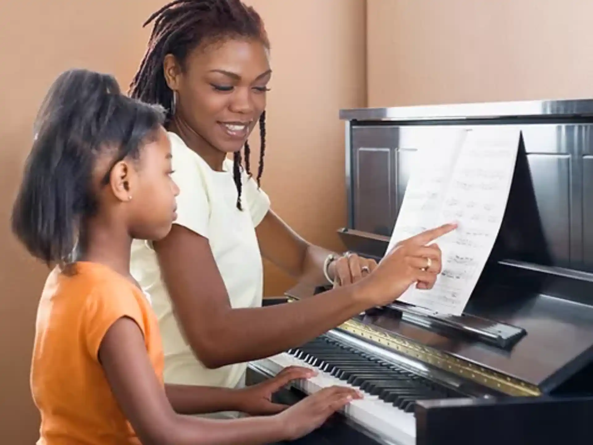 a woman showing a girl something on the paper