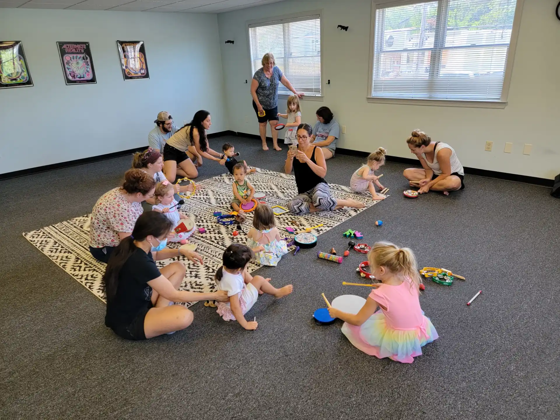 a group of people sitting on the floor playing with toys