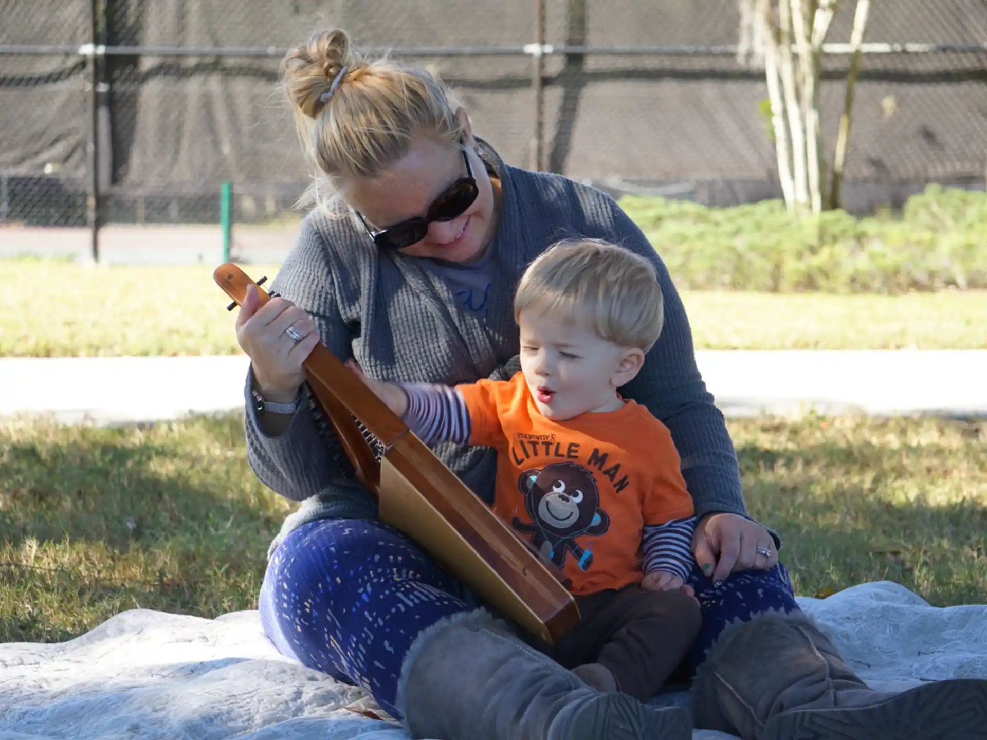 a person and a boy sitting on grass