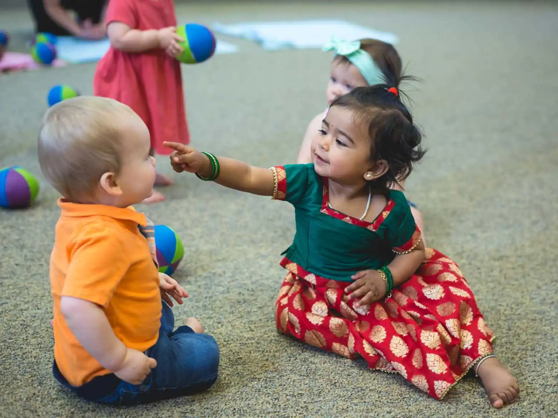 a person and two children playing on the ground