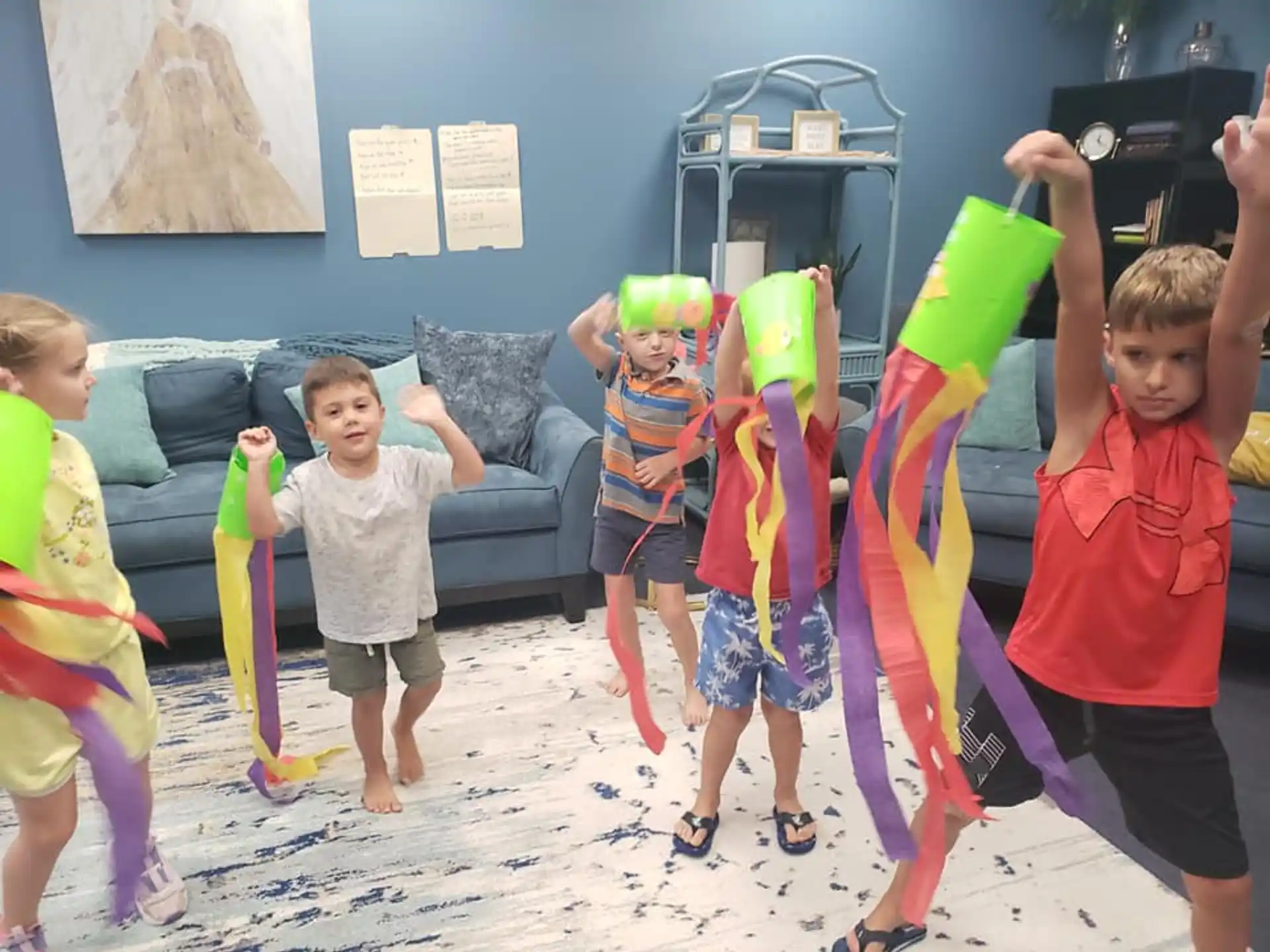 a group of children holding up colorful objects