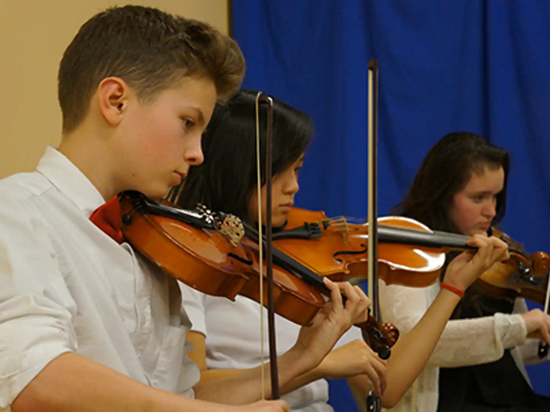 a group of kids playing violin