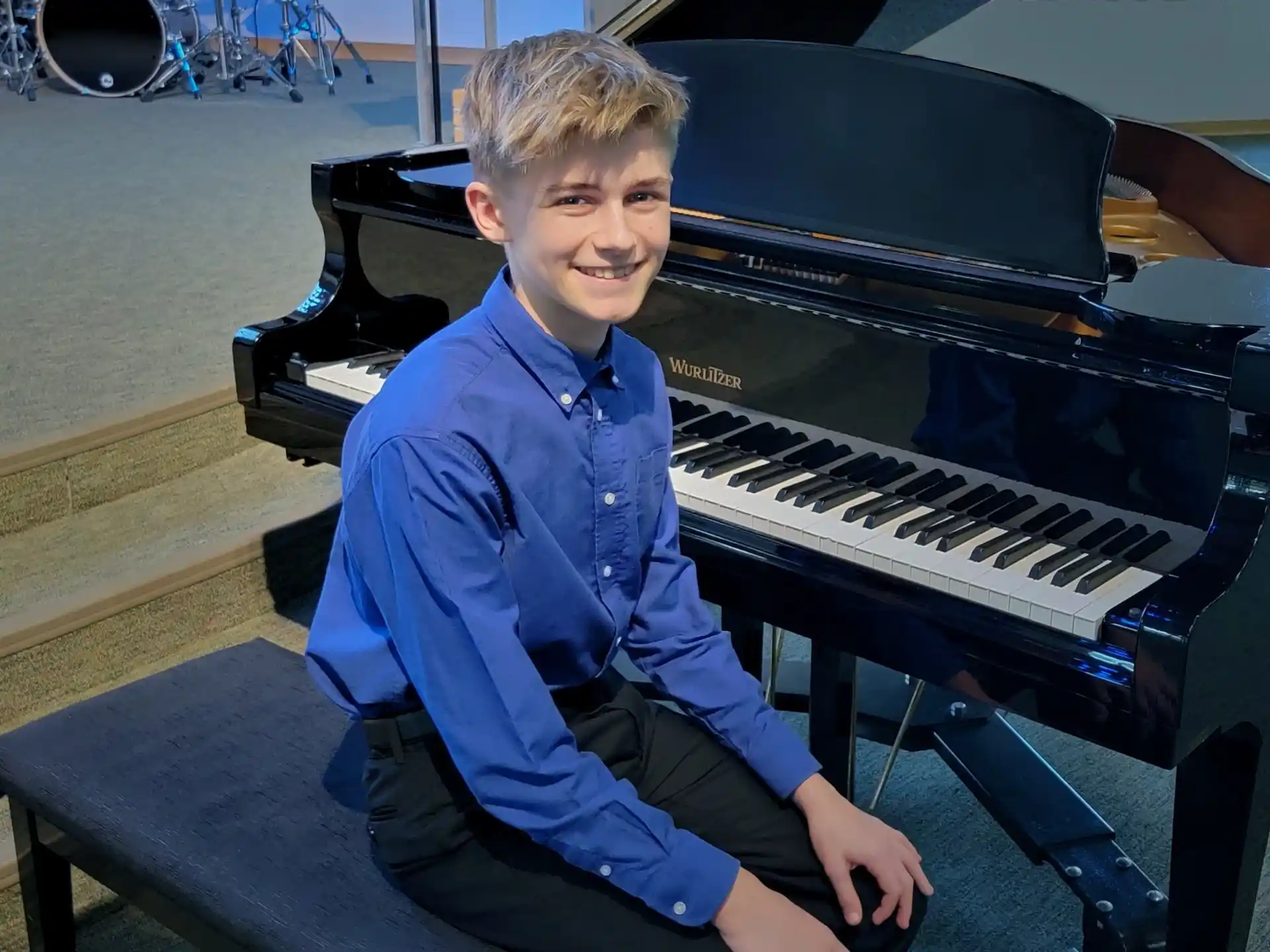 a boy sitting at a piano