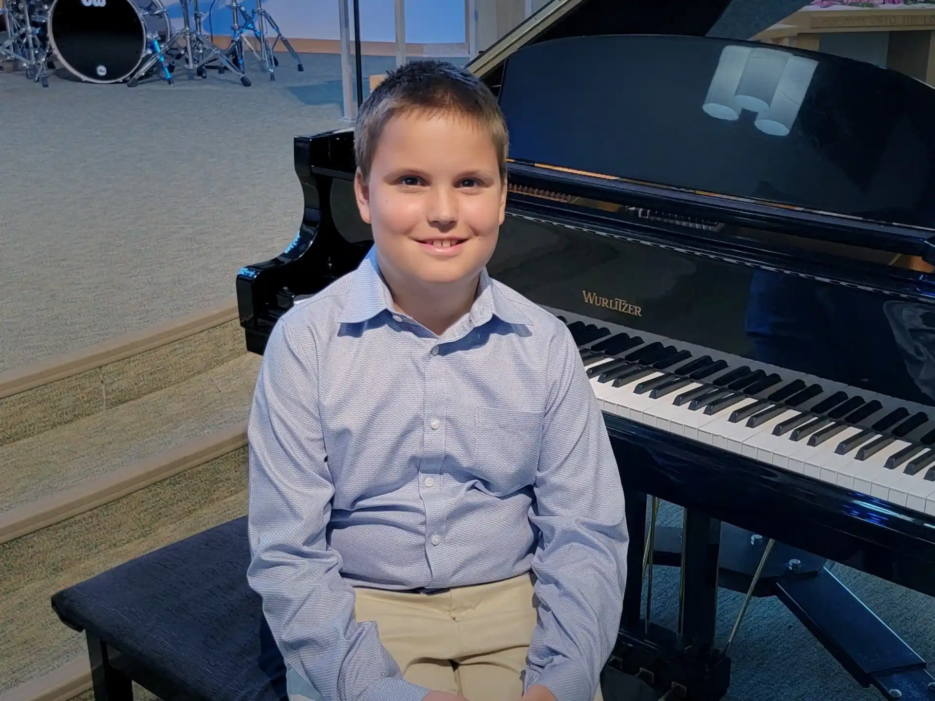 a boy sitting at a piano