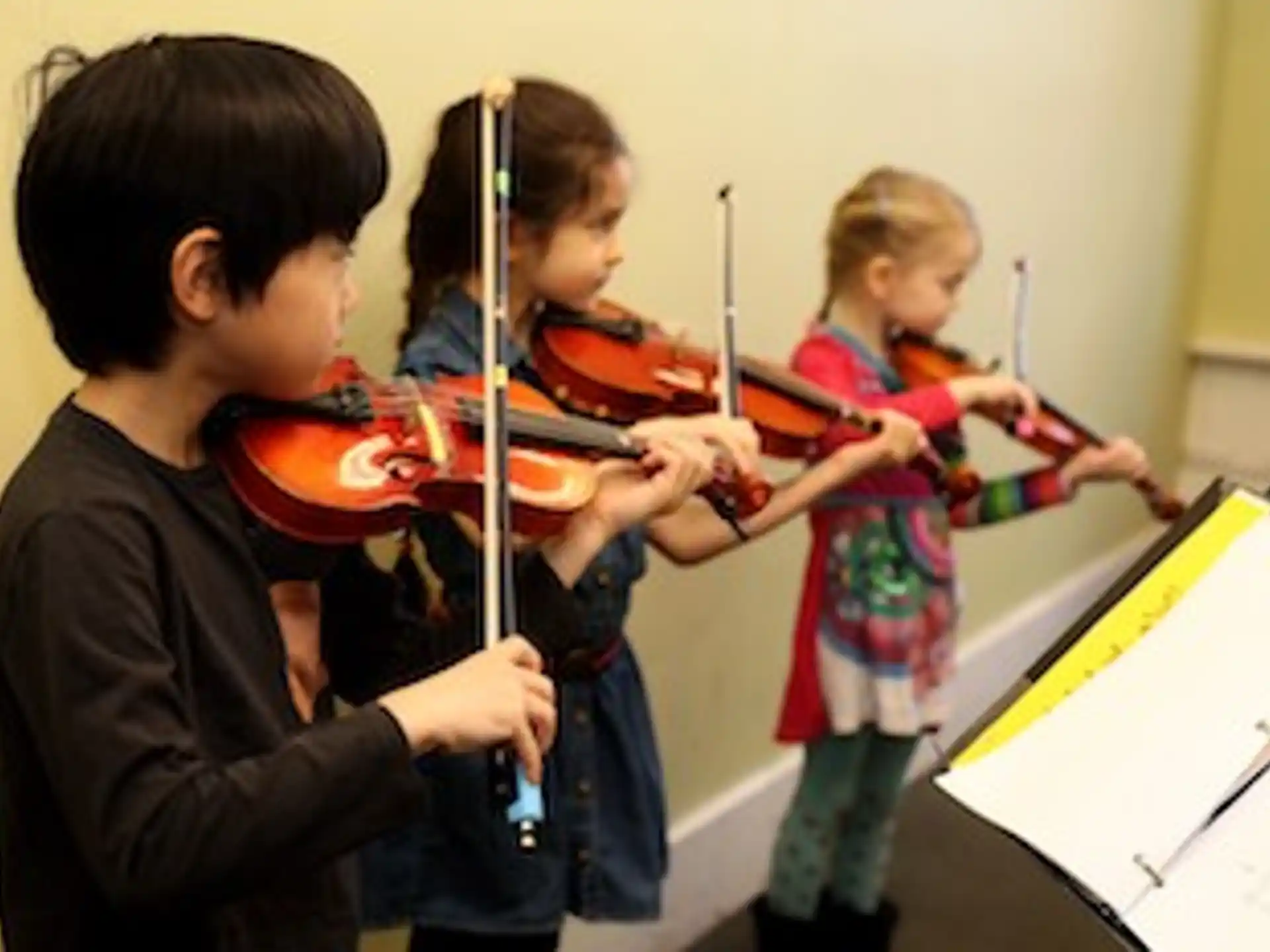 a group of children playing violin