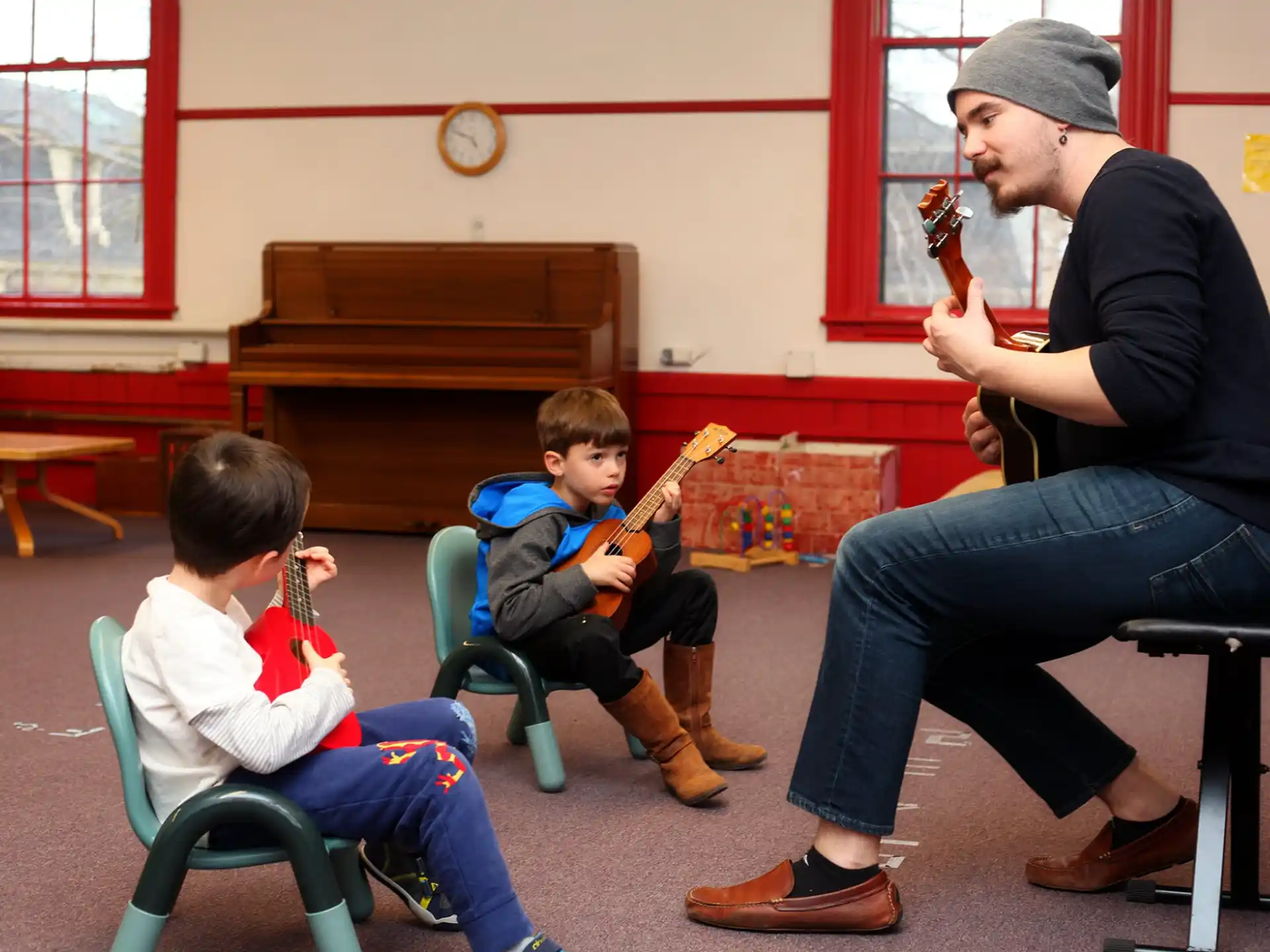 a person playing a violin to a couple of boys