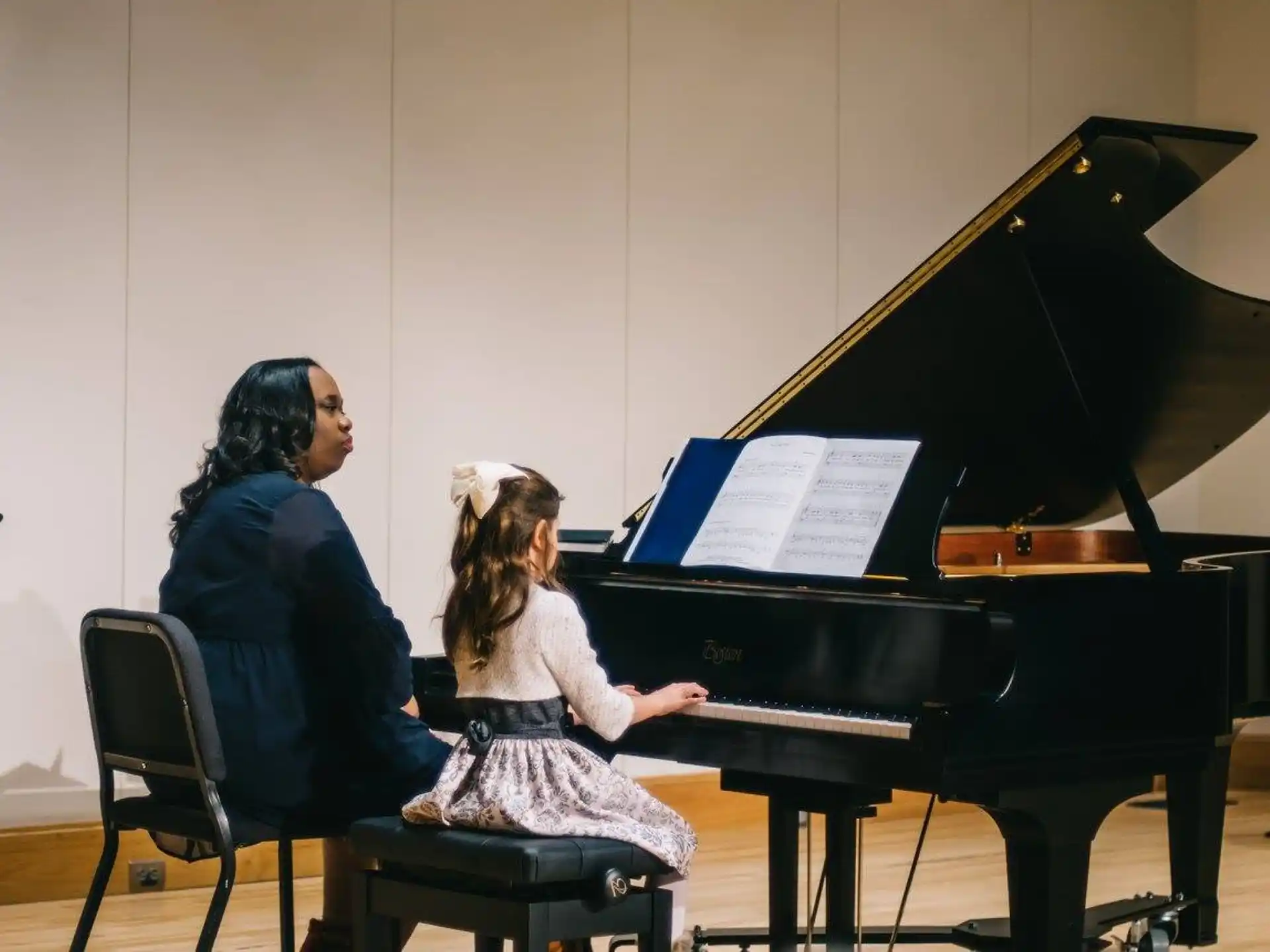 a person and a girl playing piano