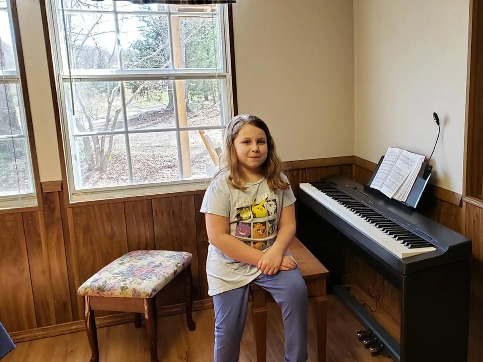 a girl sitting in front of a piano