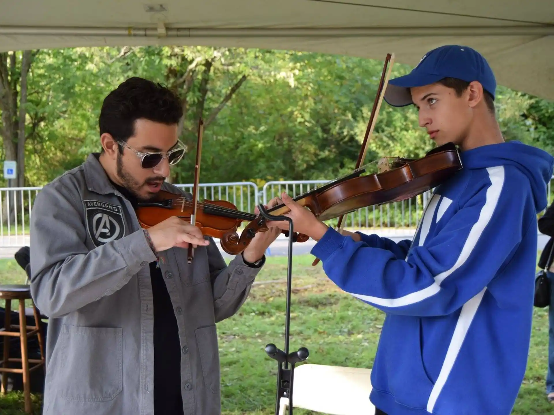 a person playing a violin next to a person playing a violin