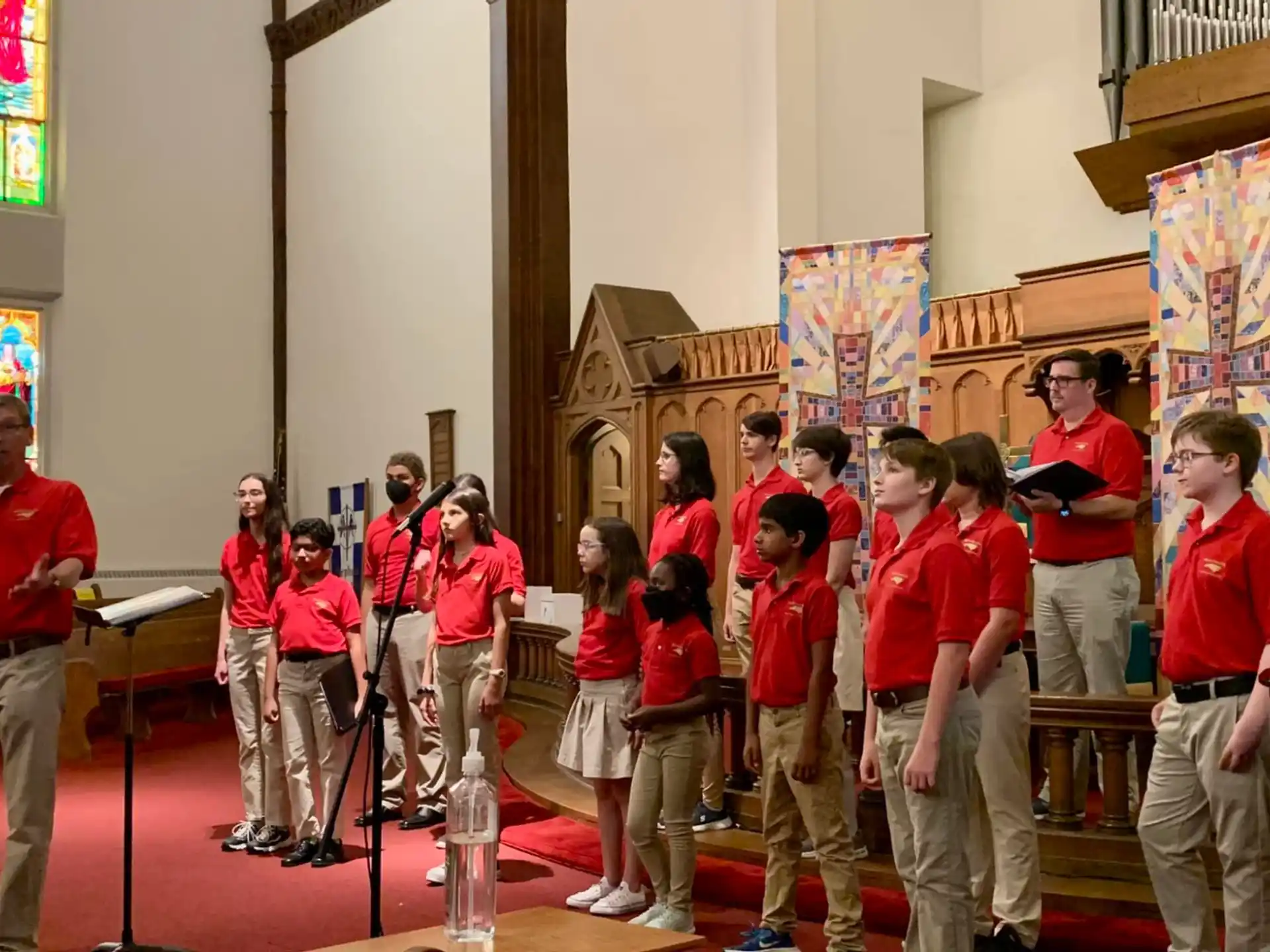 a group of people in red shirts standing in a church