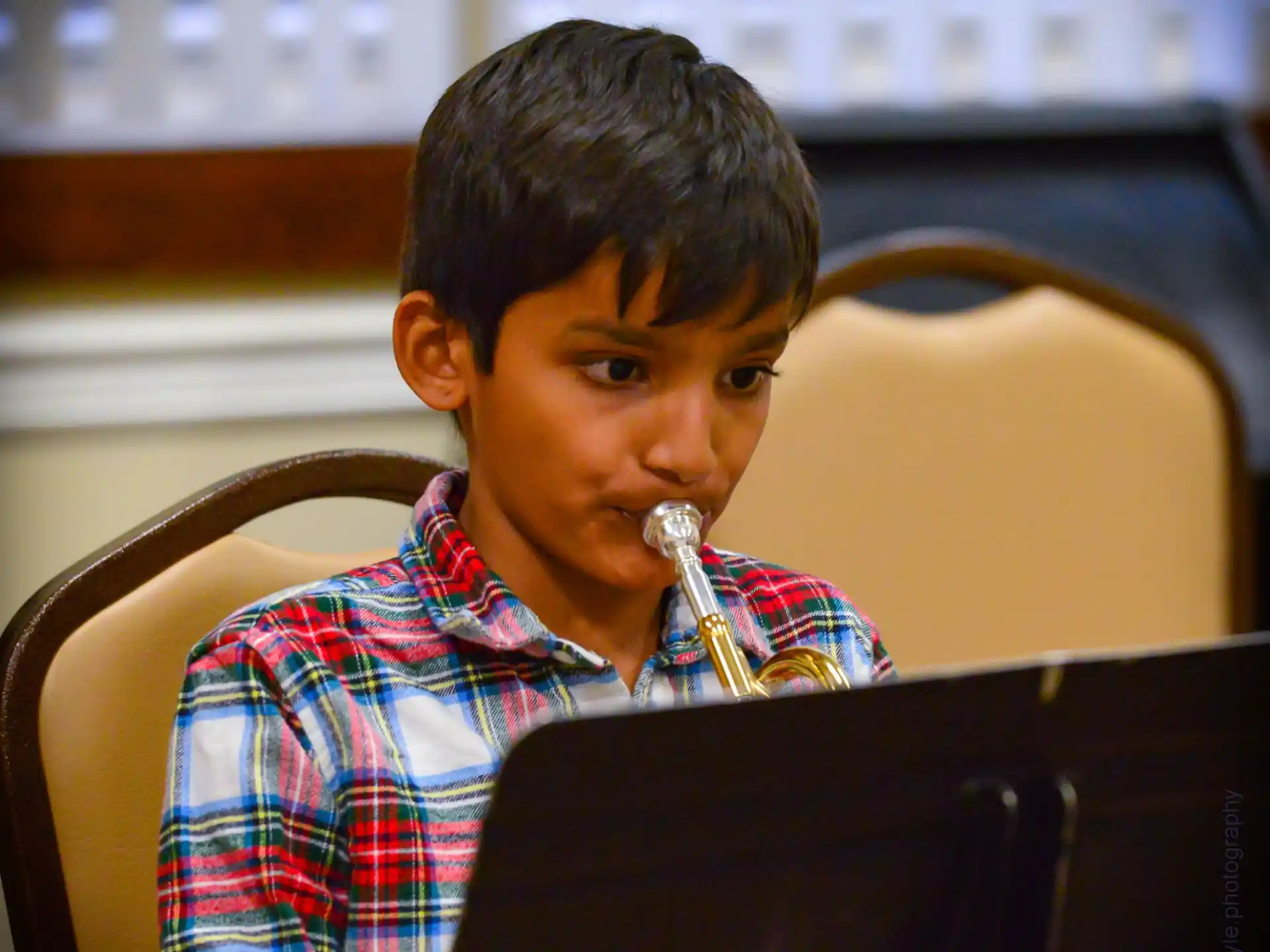 a boy sitting in a chair with a laptop