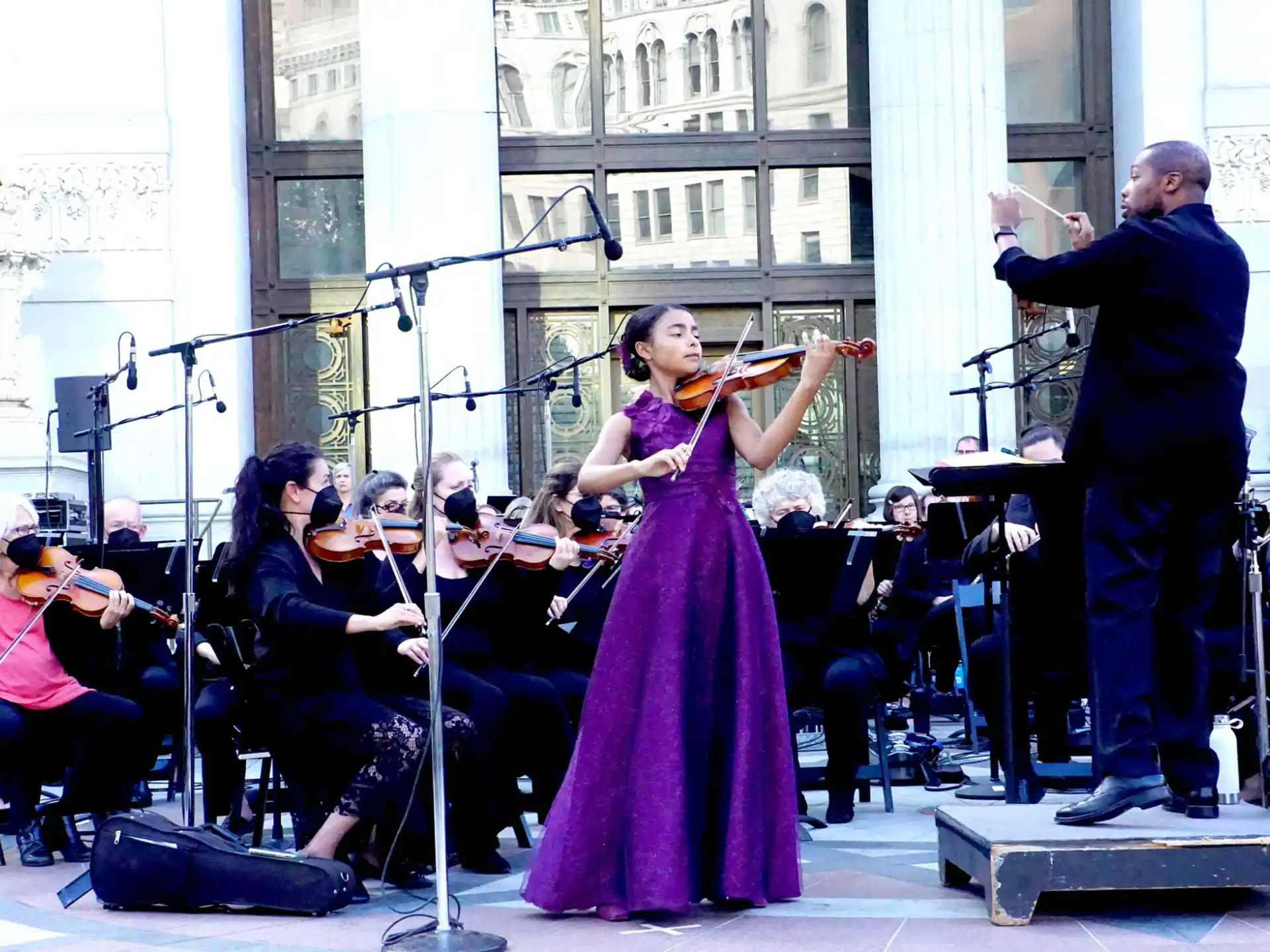 a person in a purple dress playing an instrument in front of a band