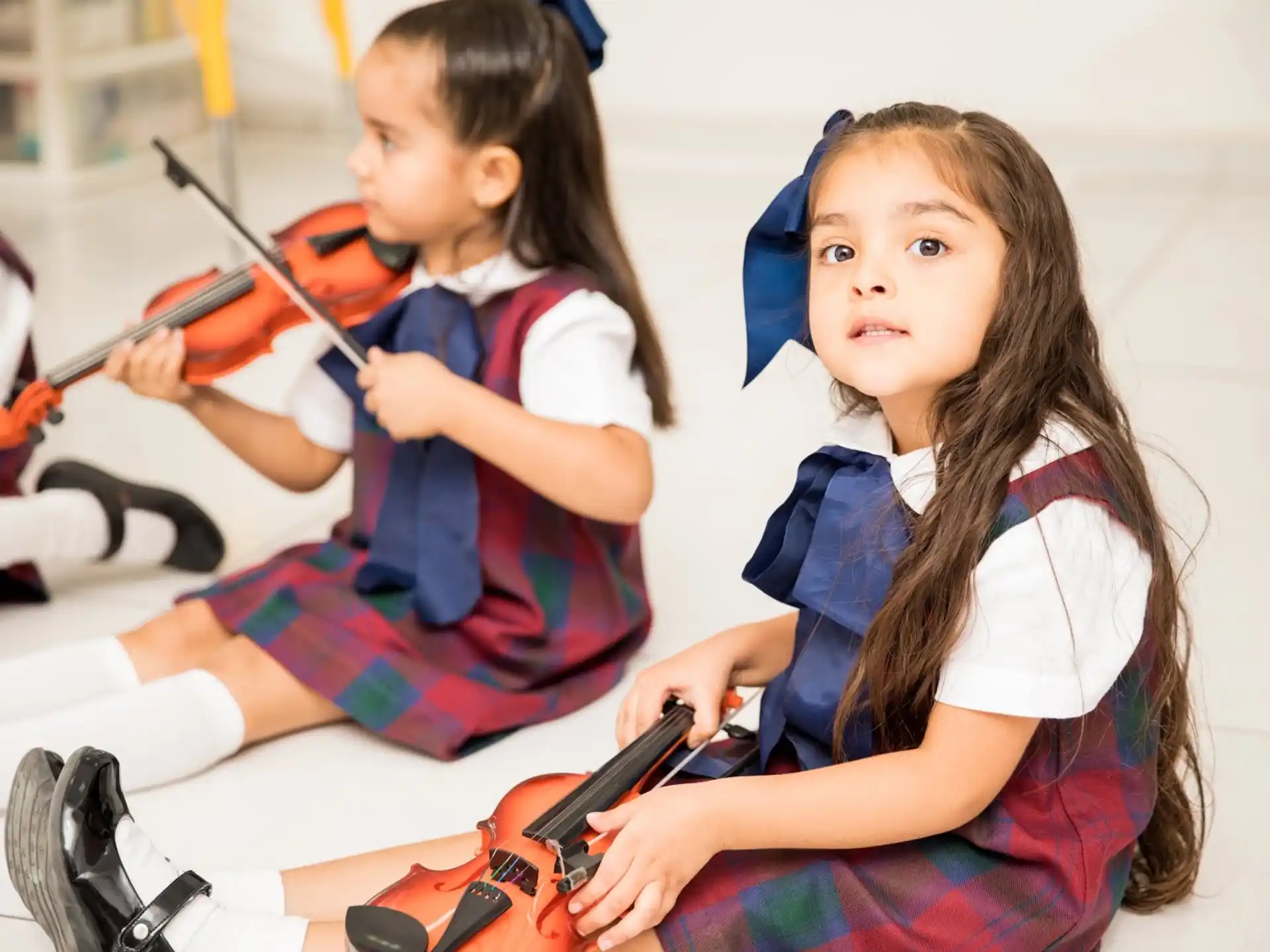 a few young girls playing violin