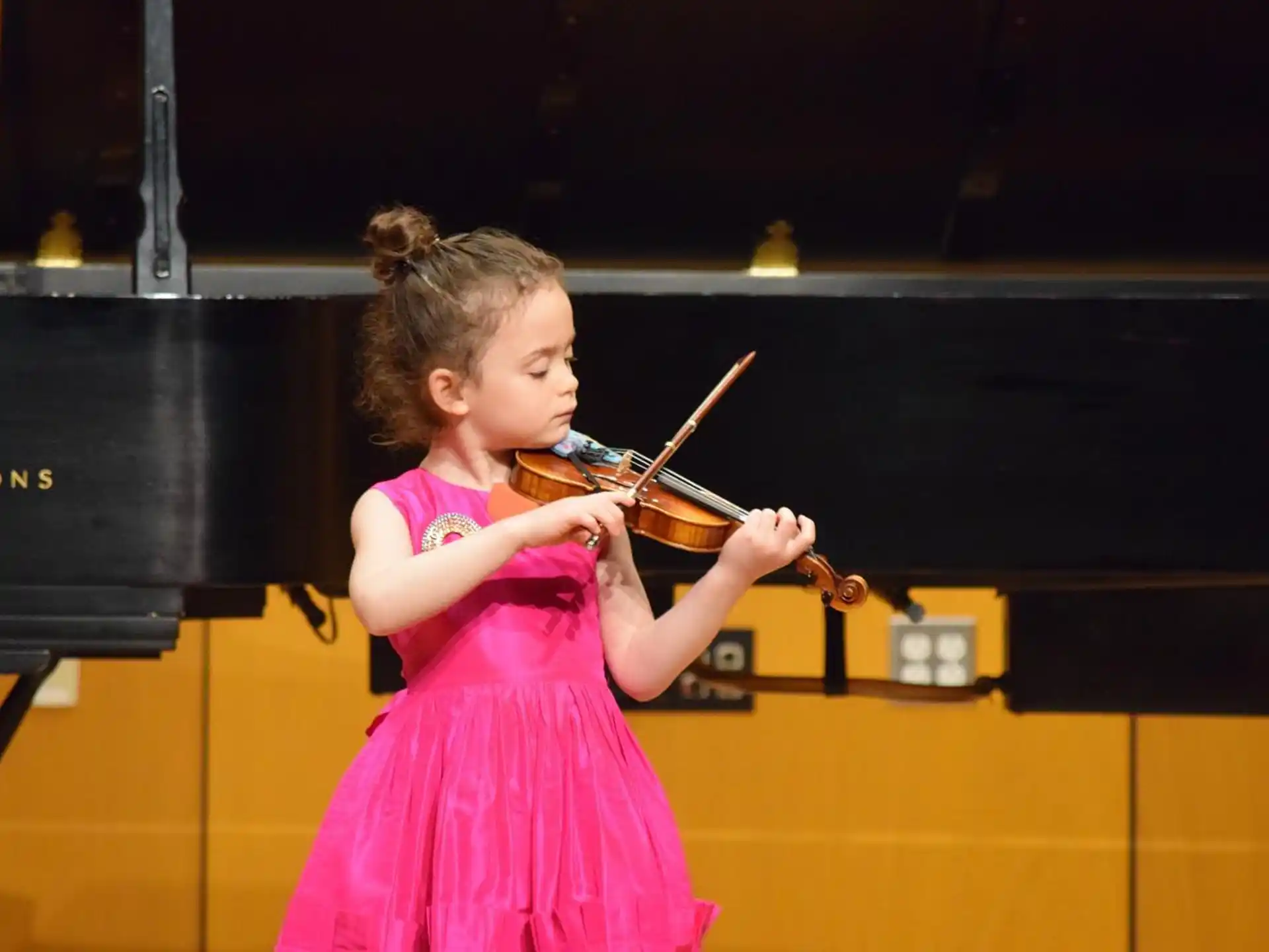 a young girl playing a violin