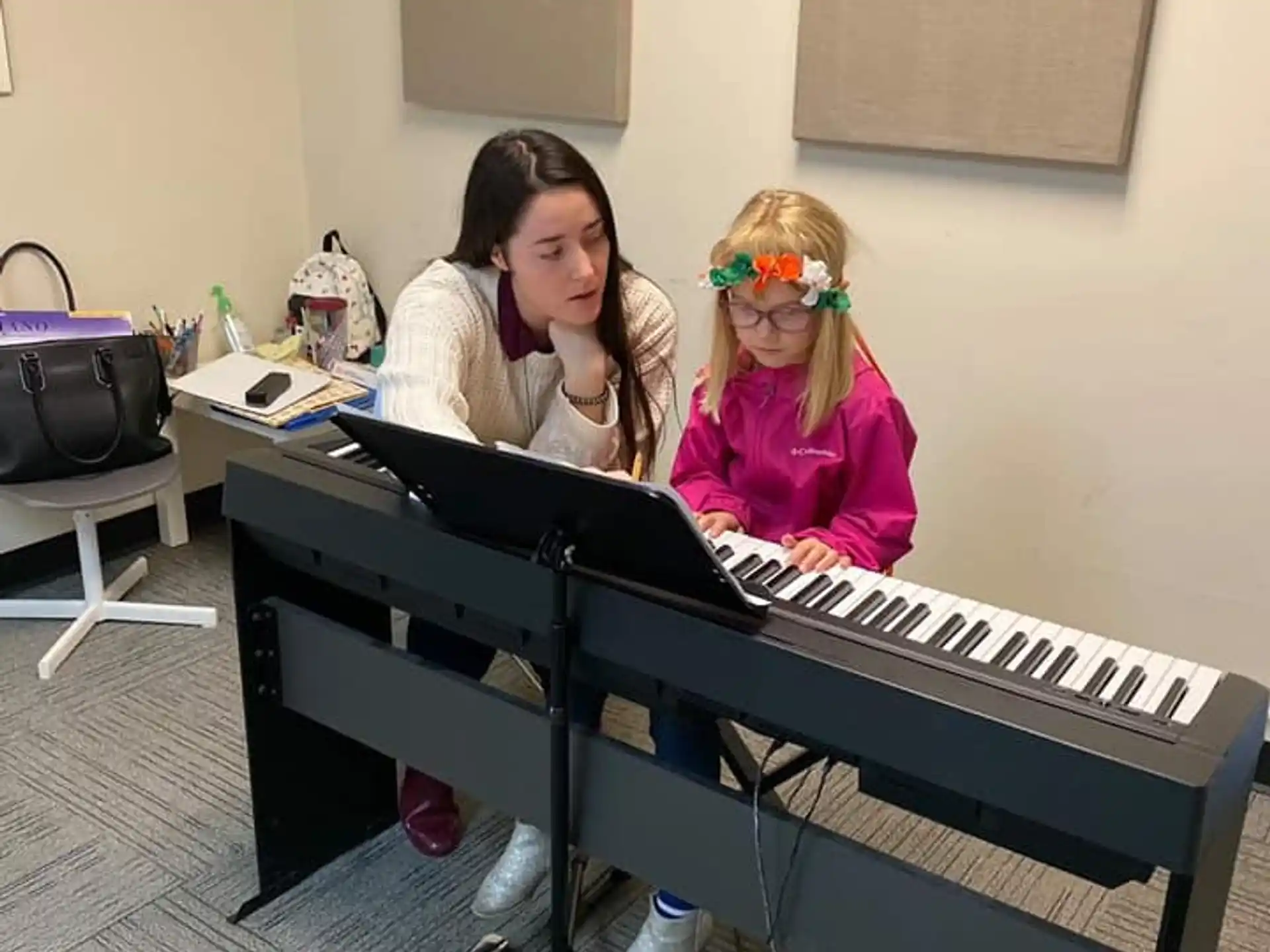 a couple of girls playing a piano
