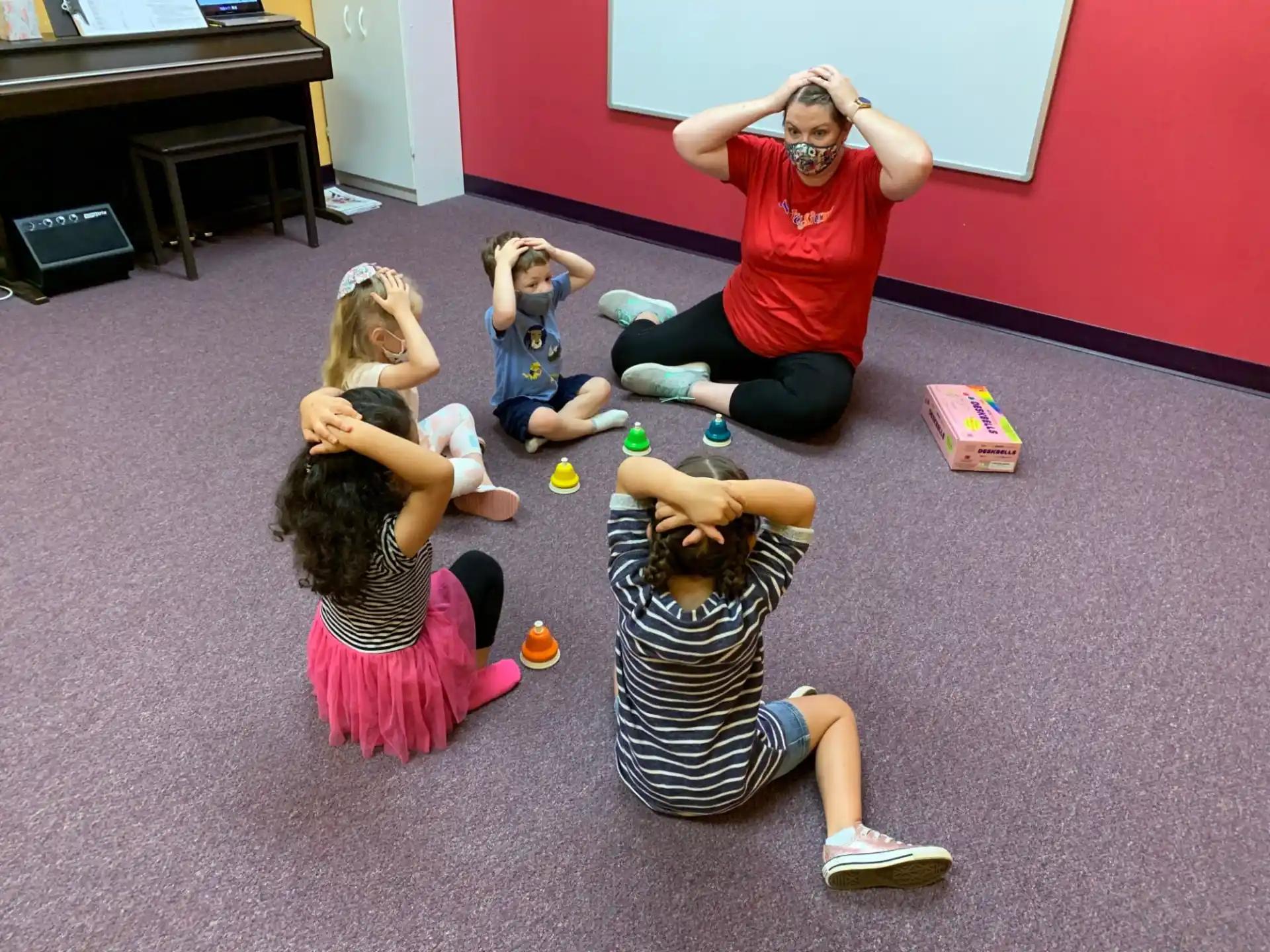 a group of people kneeling on the floor with their hands on their heads