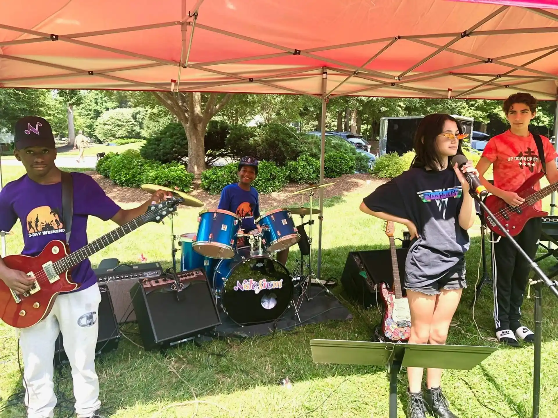 a group of people playing instruments under a tent