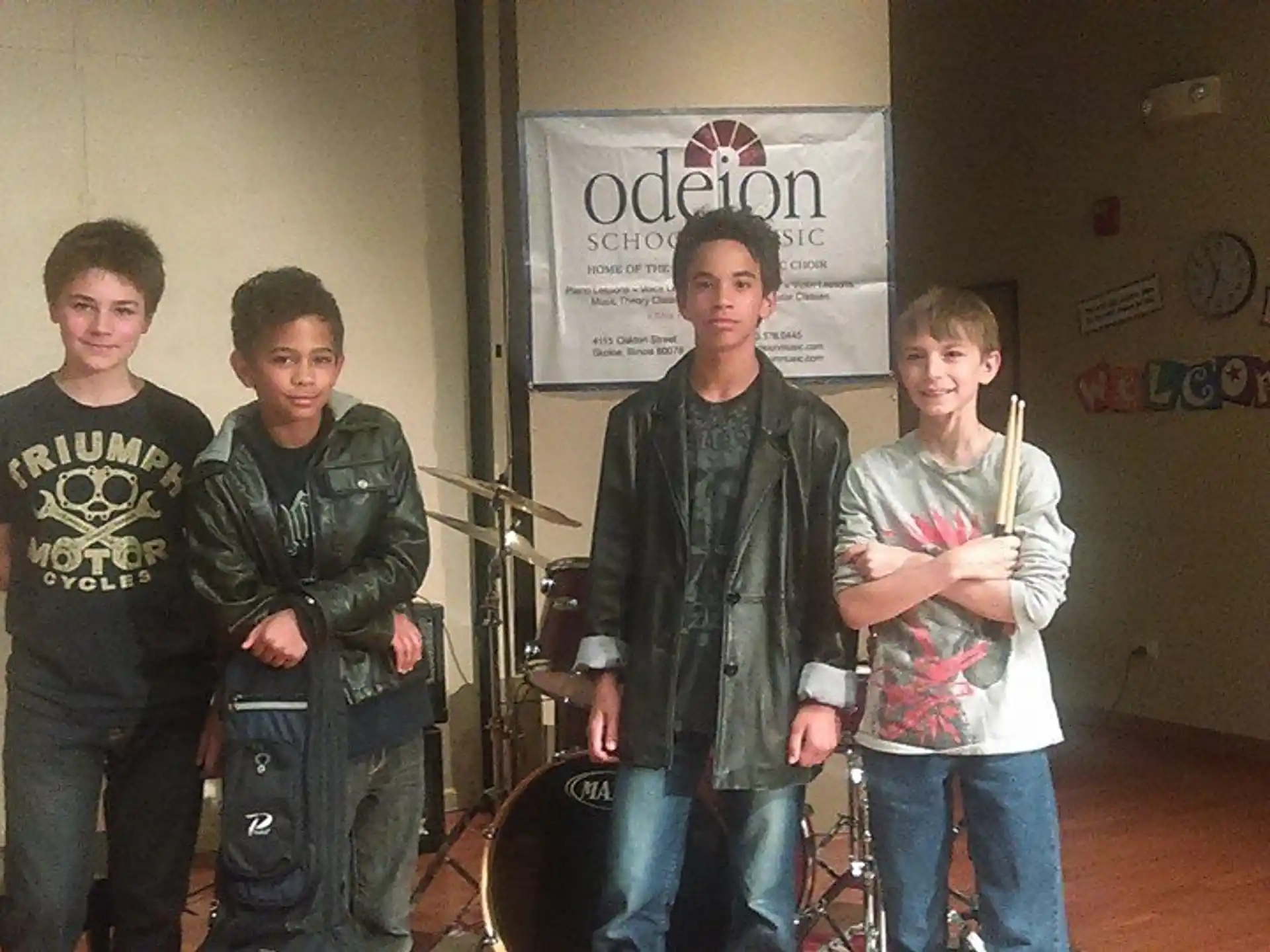 a group of boys standing in a room with drums