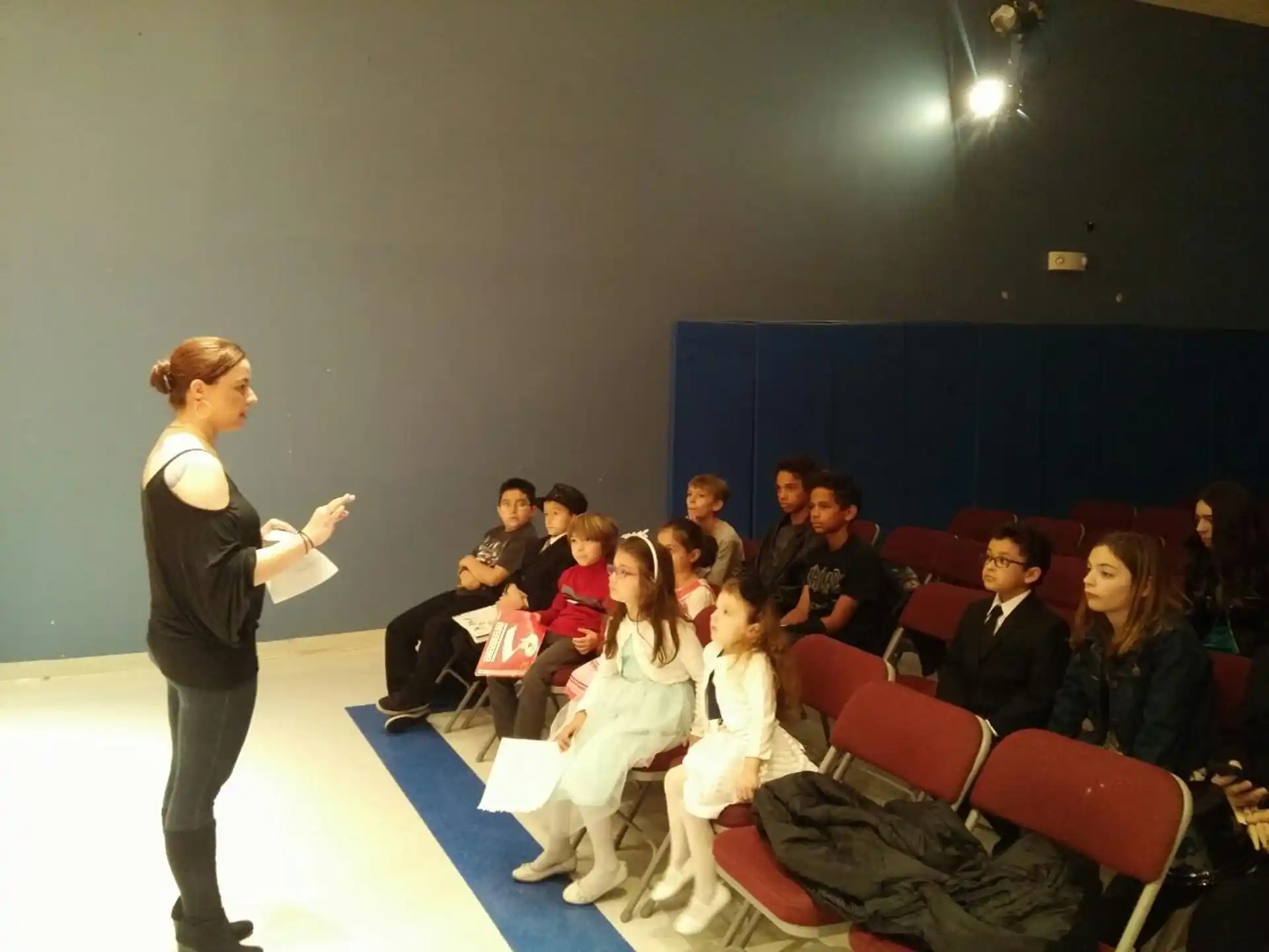 a person standing in front of a group of people sitting in chairs