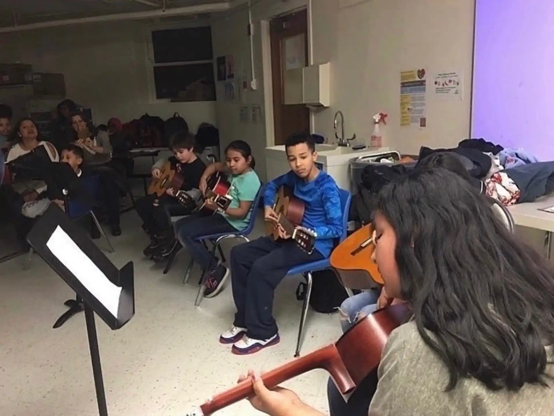 a group of people sitting in a room playing instruments