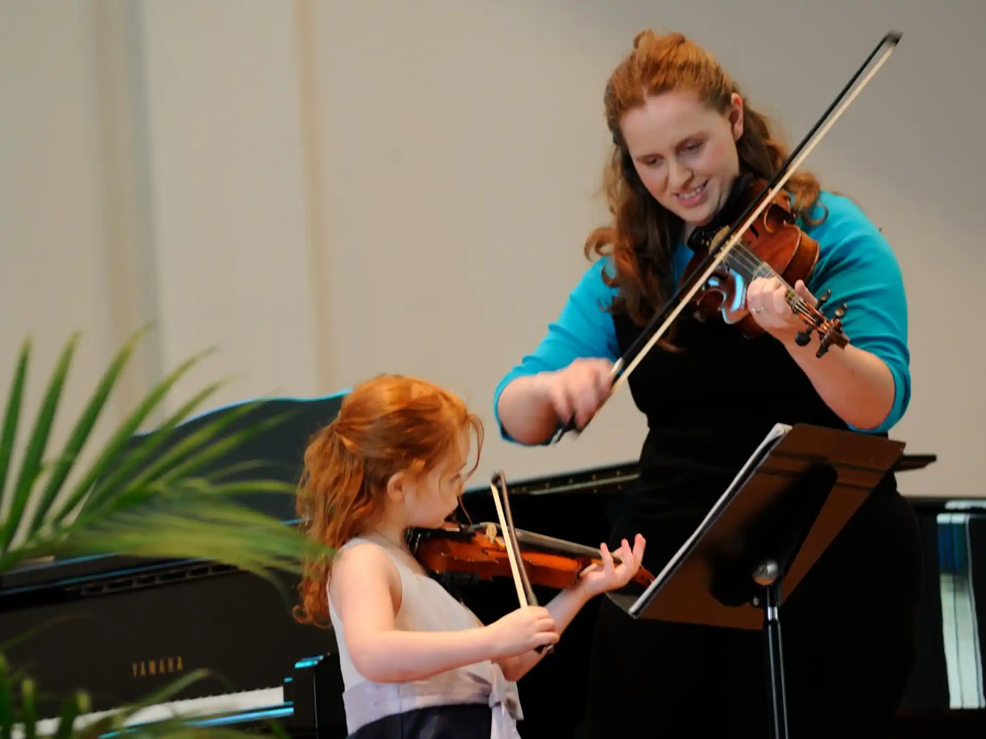 a person playing a violin next to a young girl