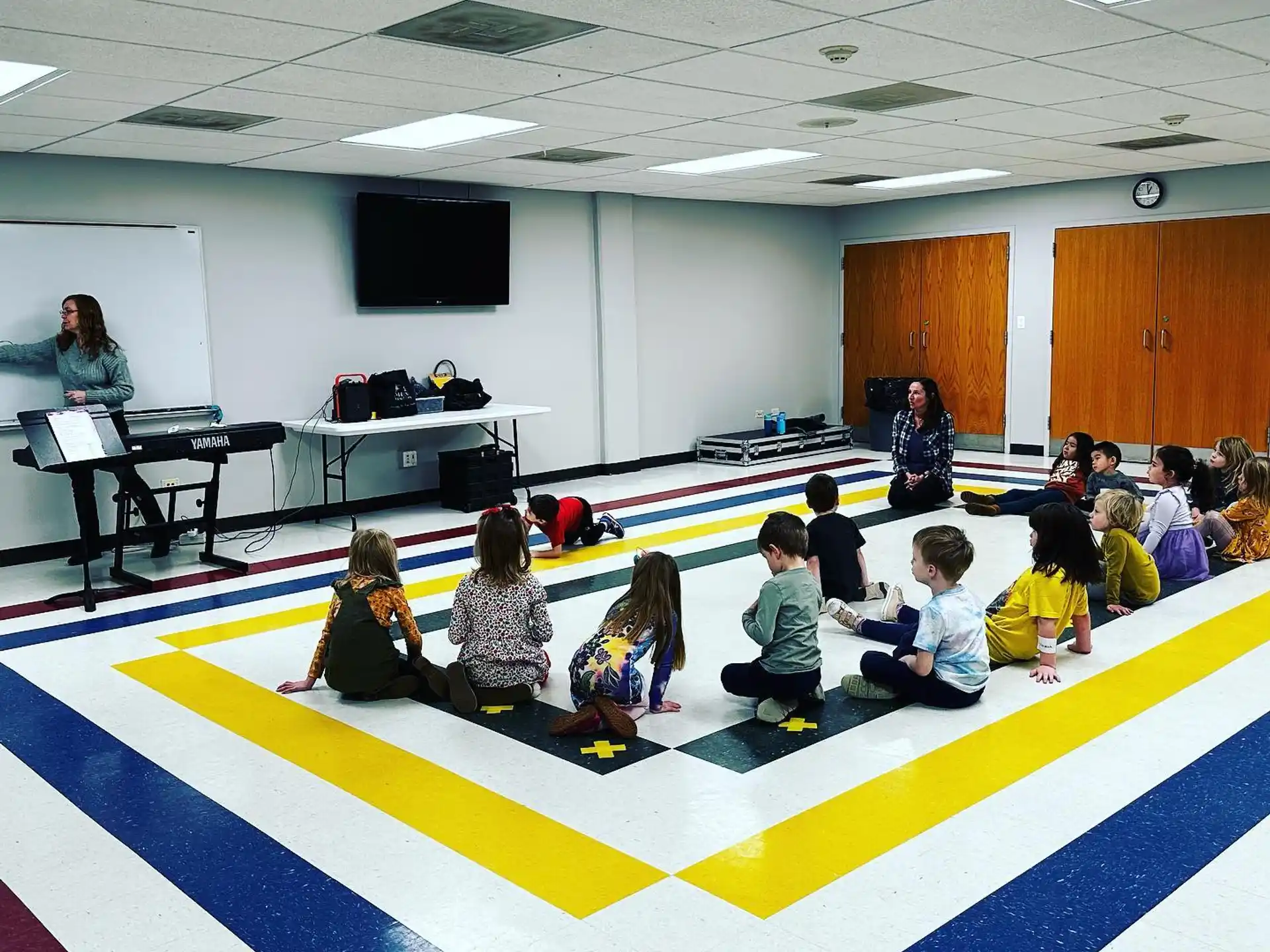 a group of children sitting on the floor in a room