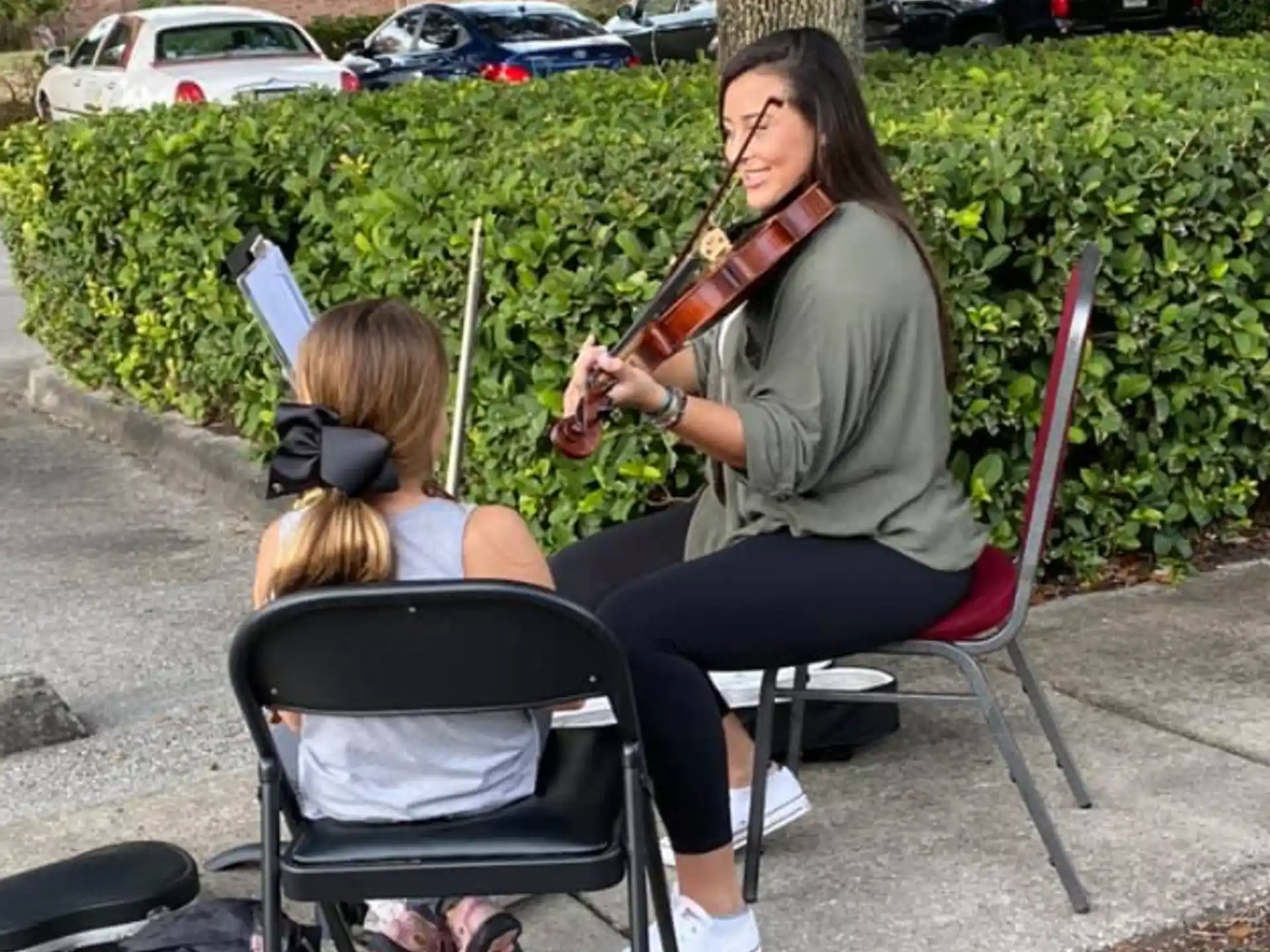 a person playing a violin to a young girl