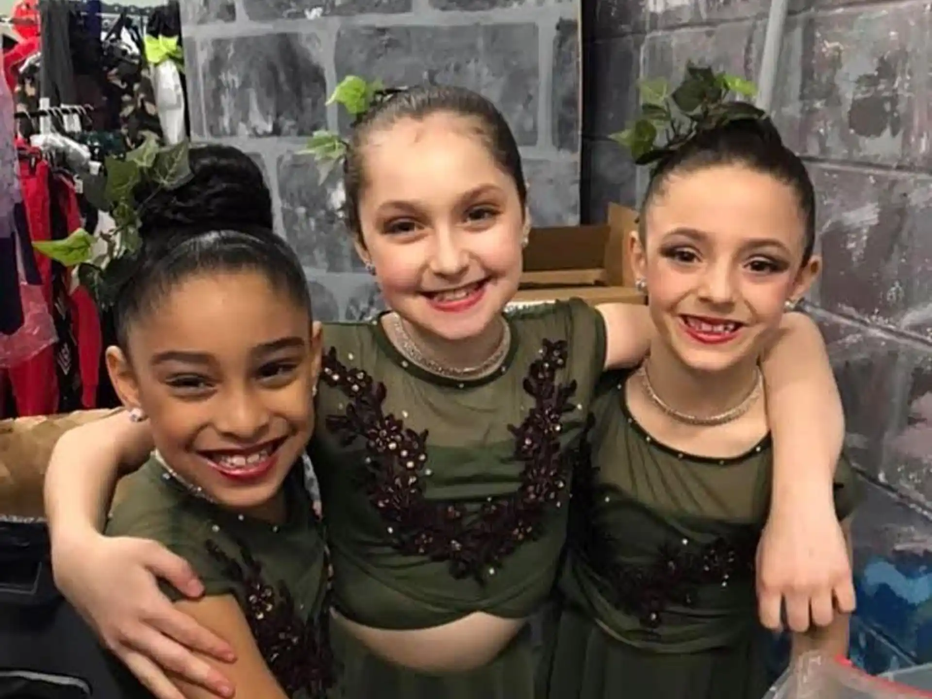a group of children in green dresses