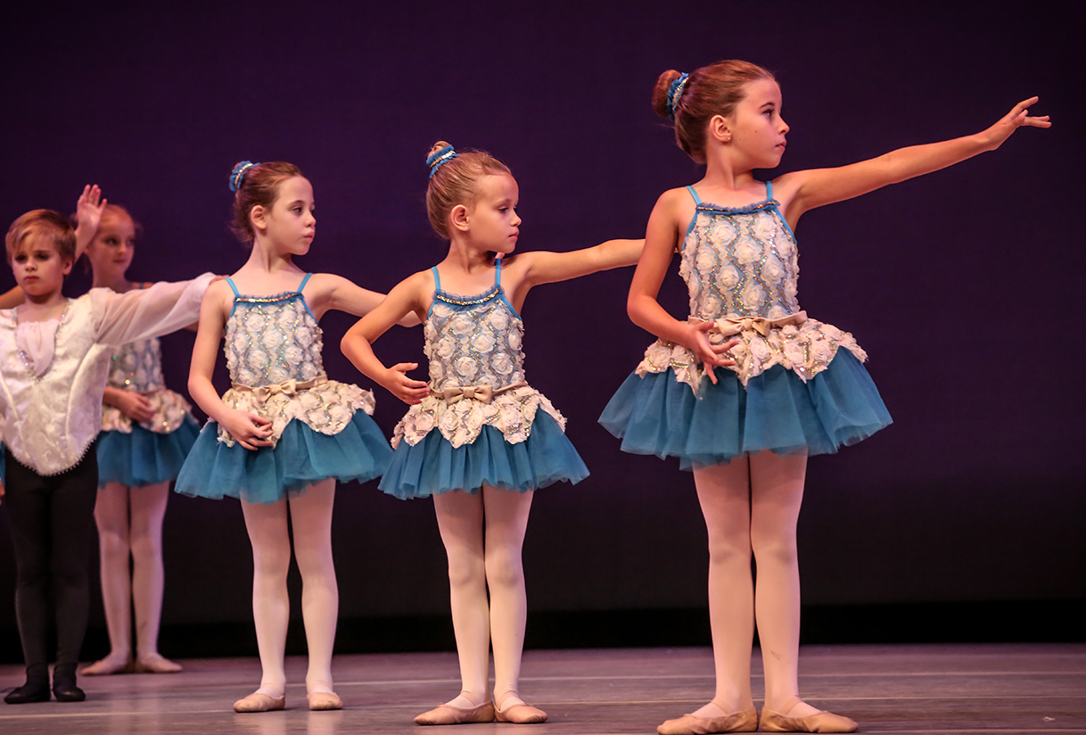 a group of girls in blue dresses