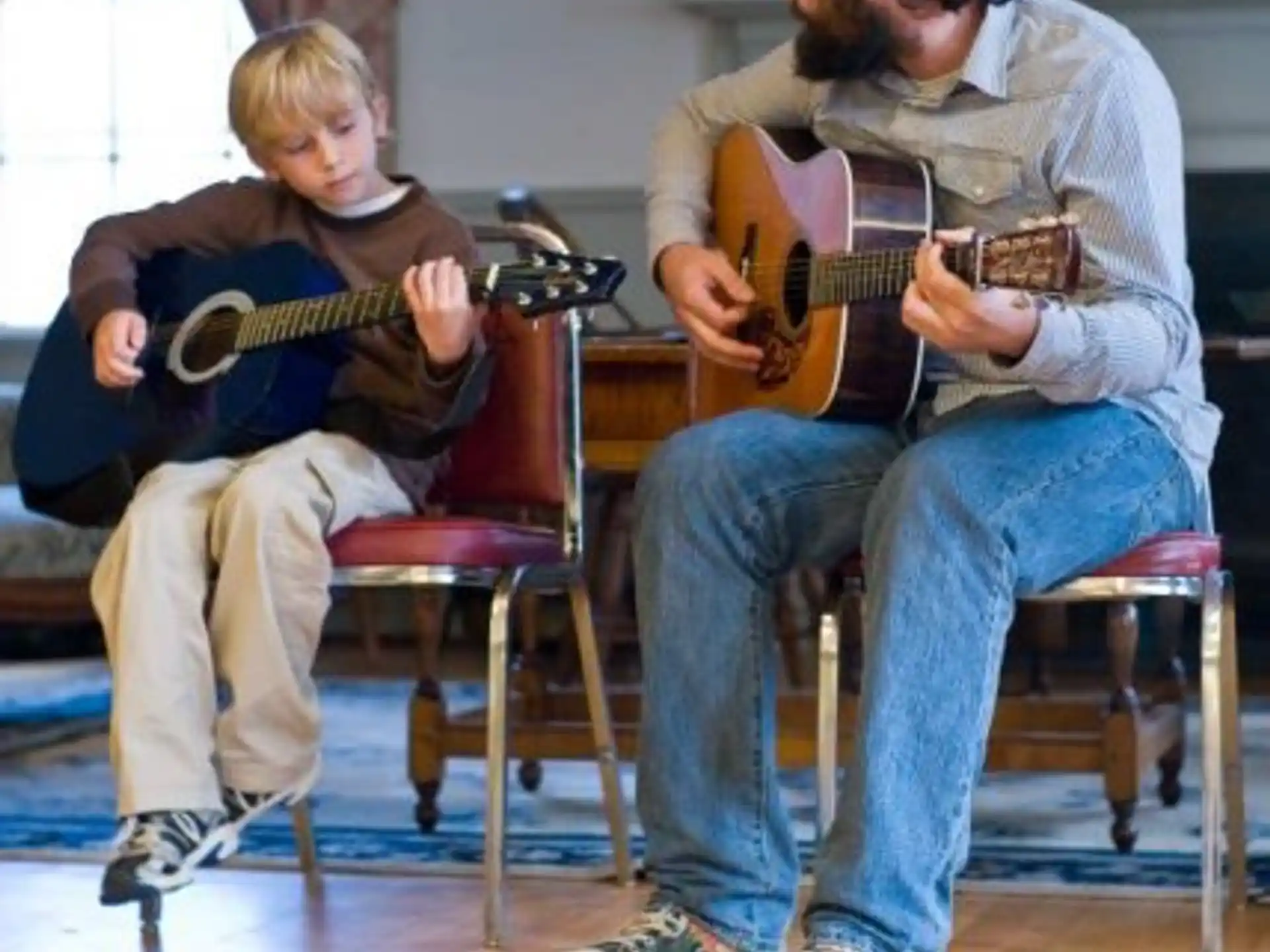 a person and a boy playing guitars