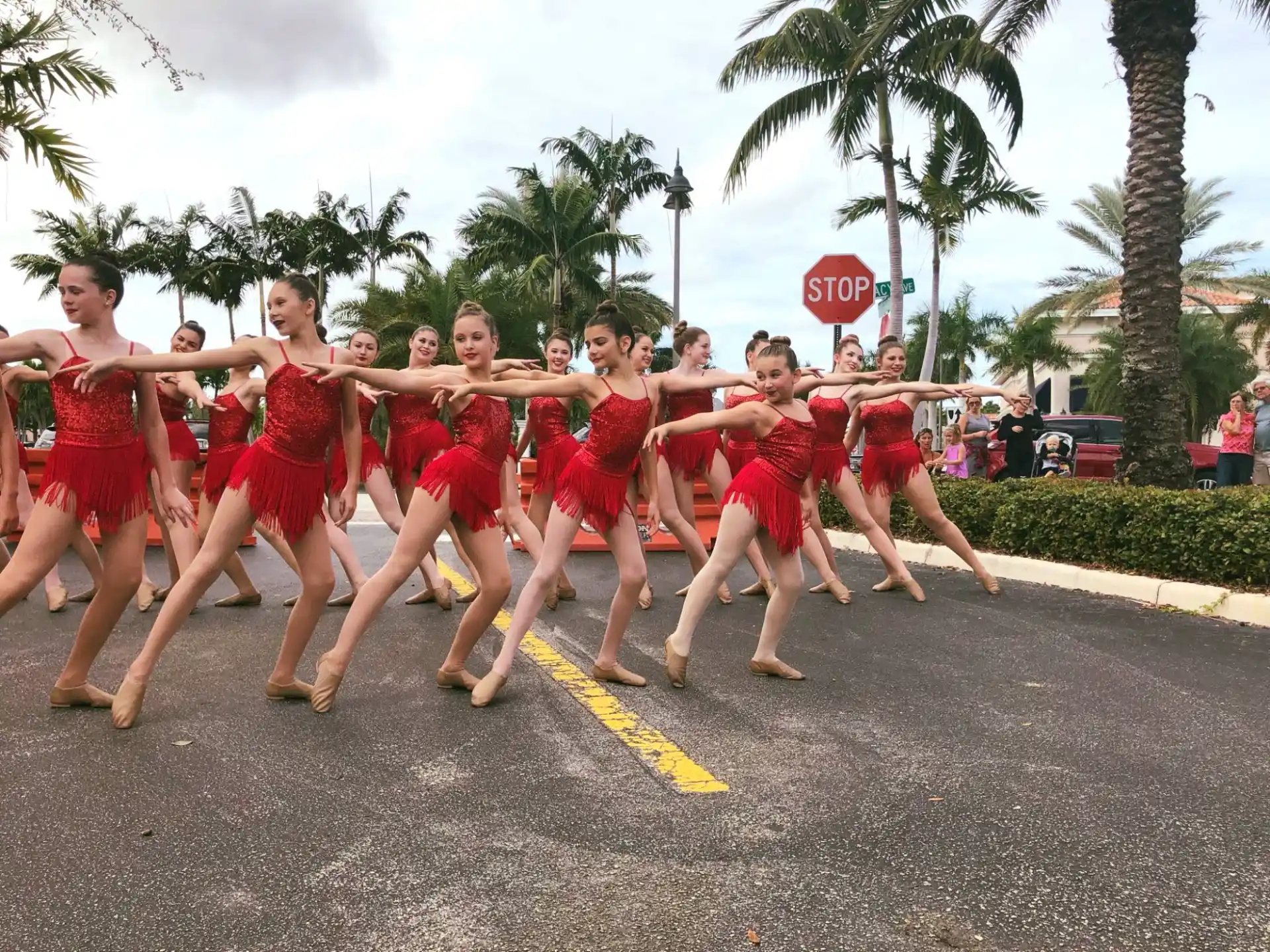 a group of women in red dresses running down a street