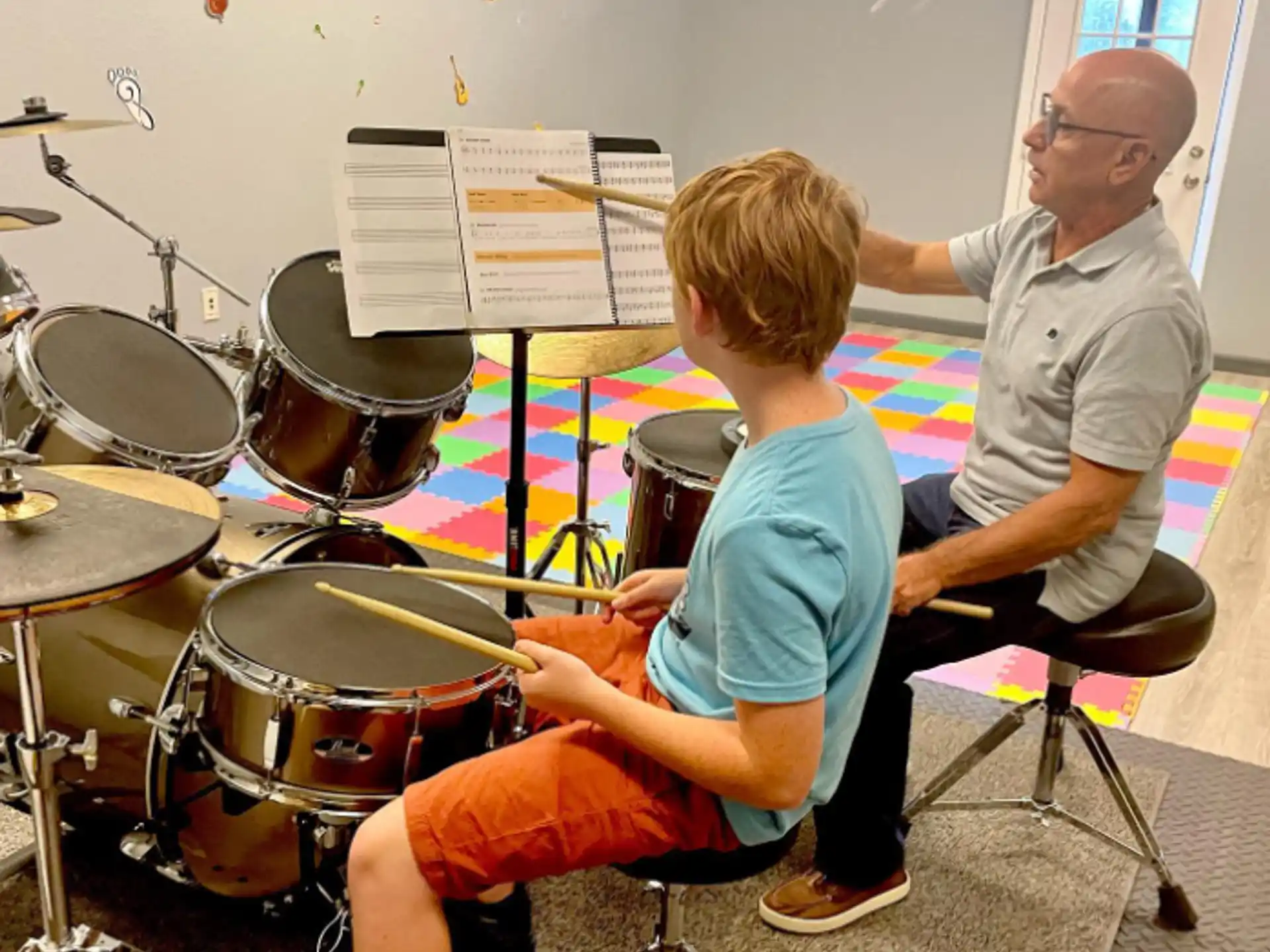 a person and a boy playing drums