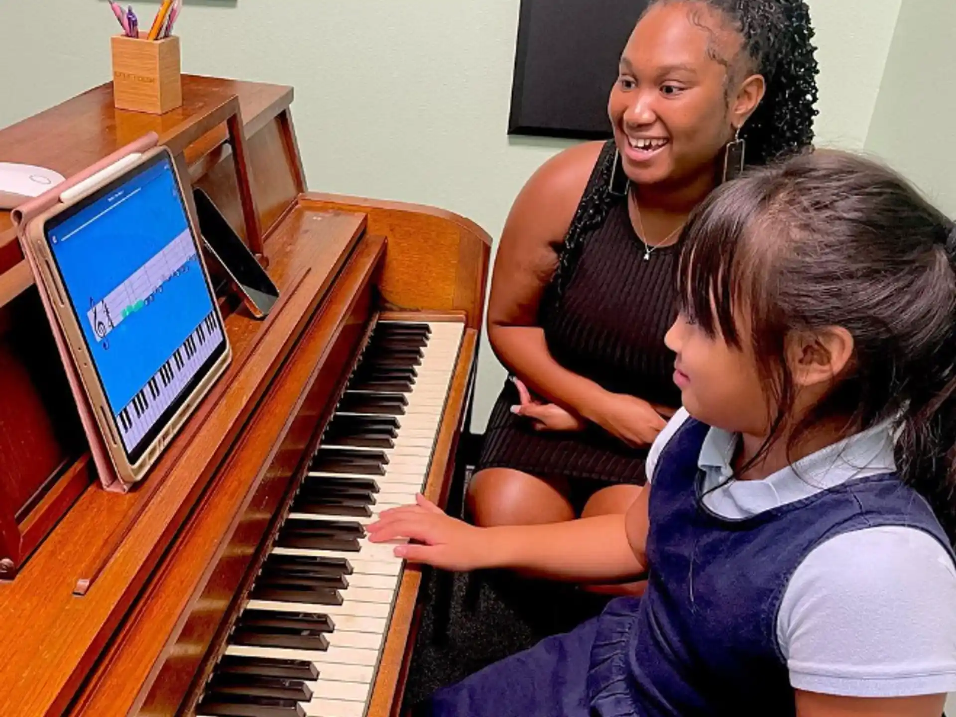 a person playing a piano with a young girl