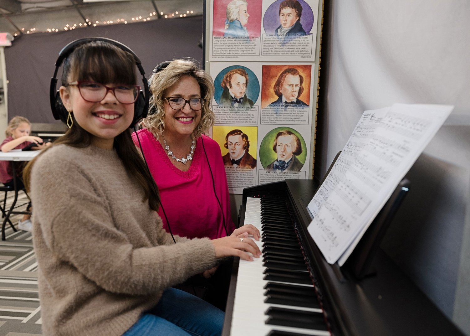 a couple of women holding a piano