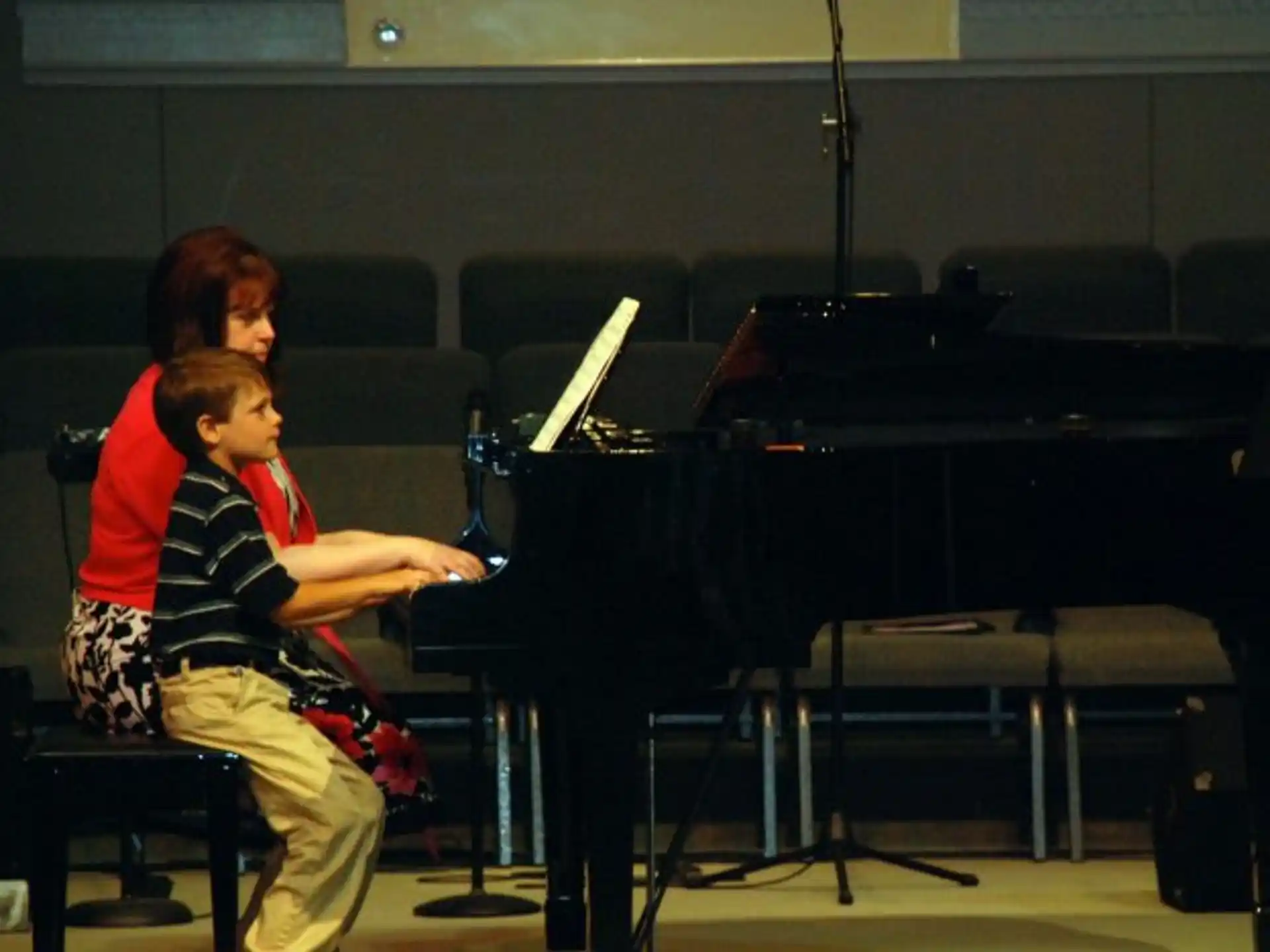 a person and a boy playing piano