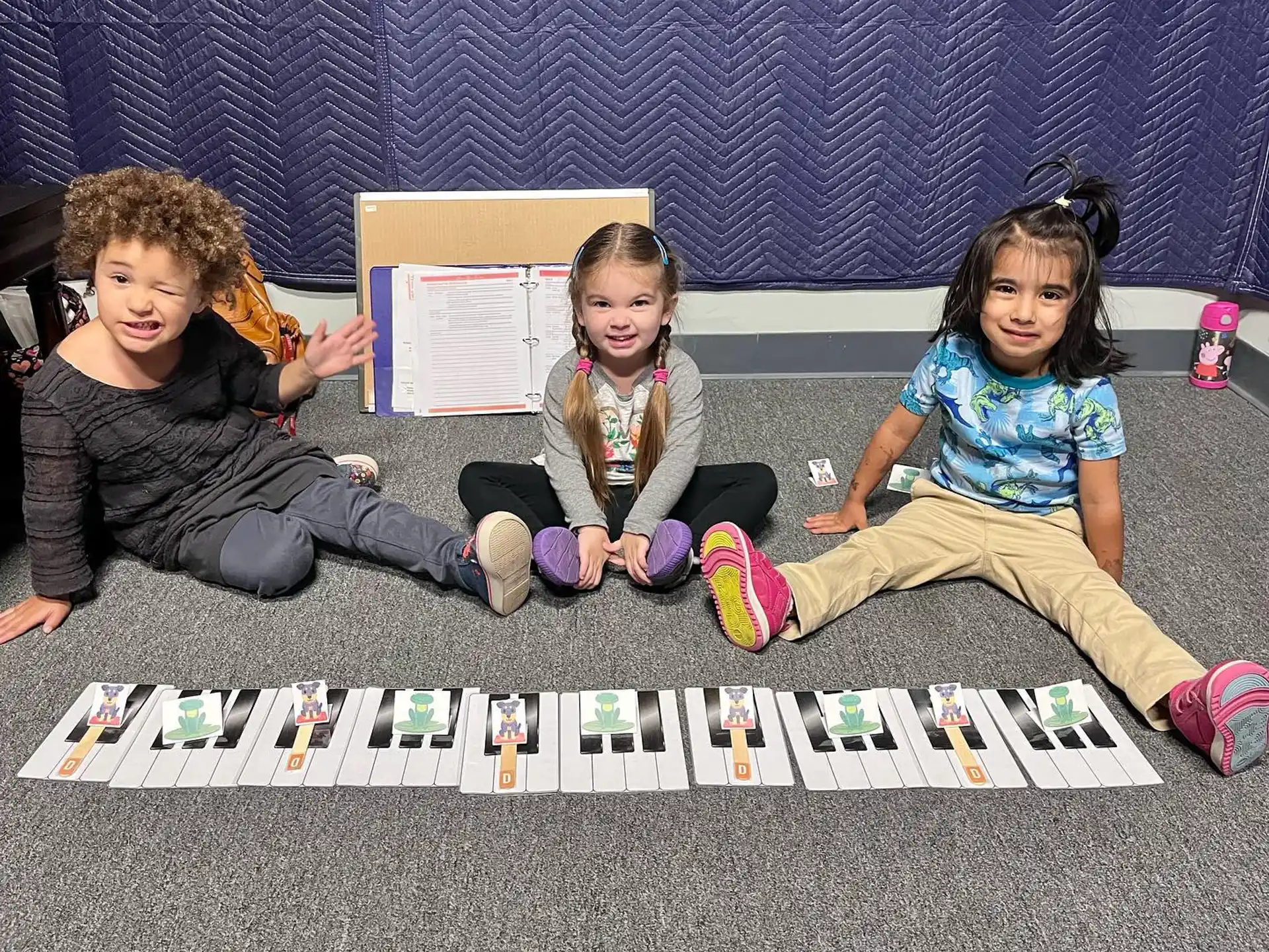 a group of children sitting on the floor holding a book