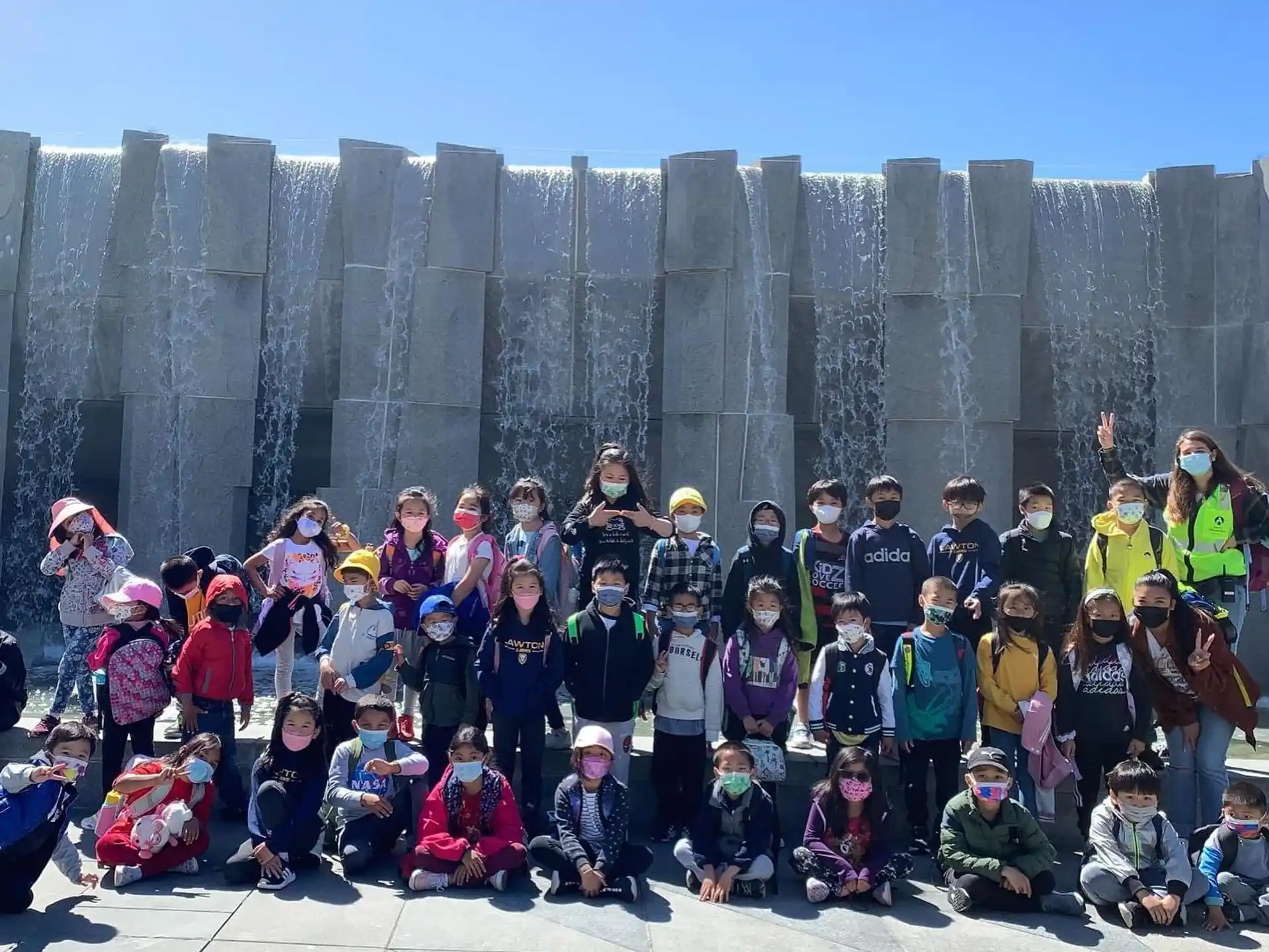 a group of people posing for a photo in front of a stone wall