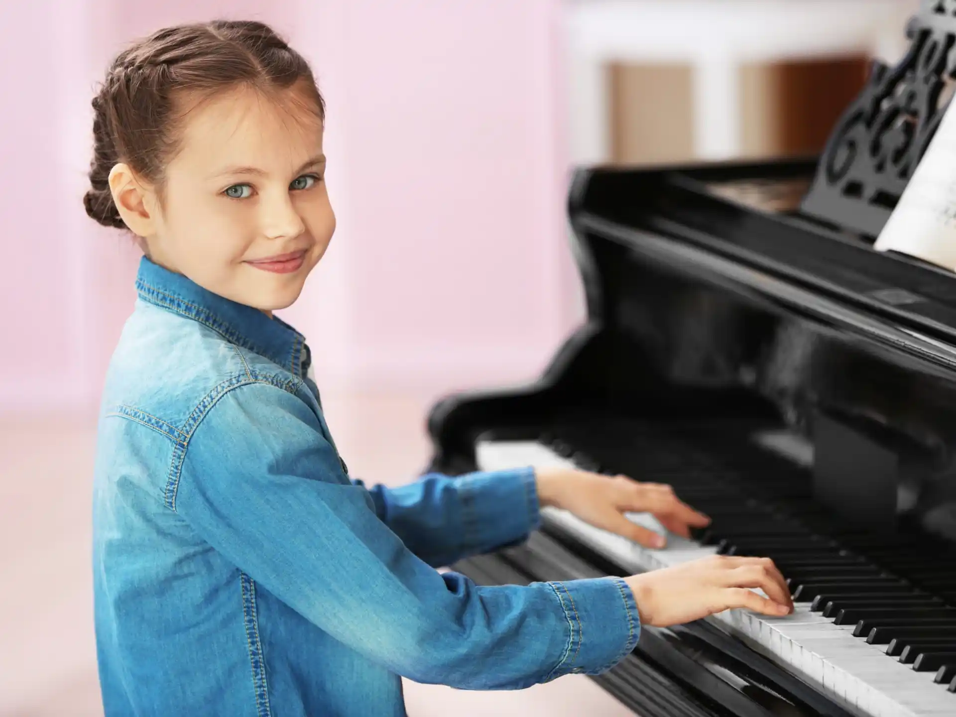 a young girl playing a piano