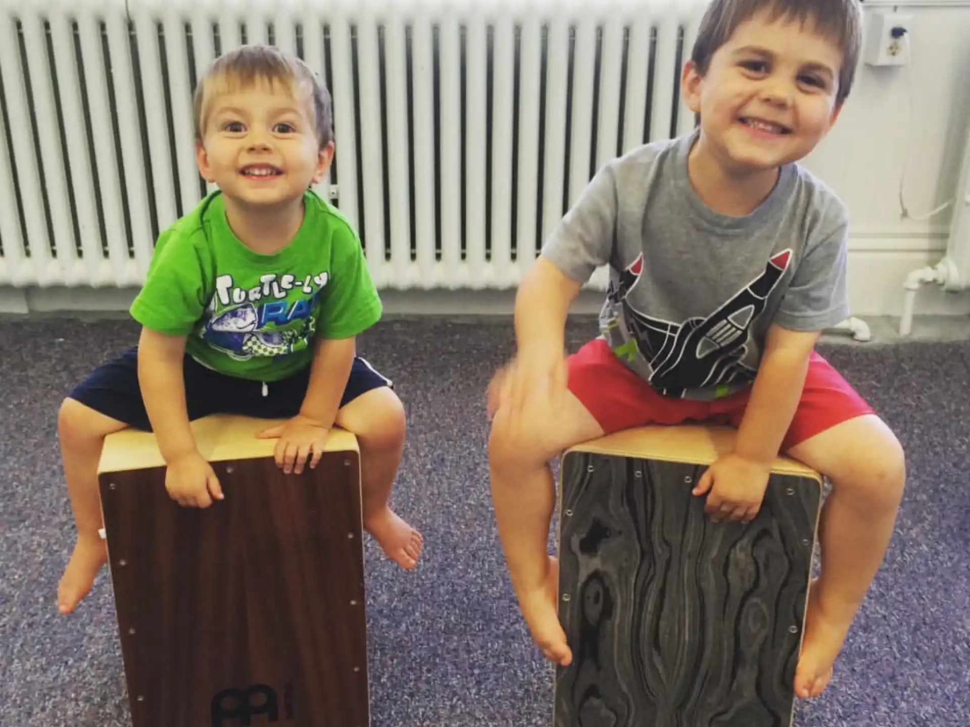 two kids sitting on large black bags