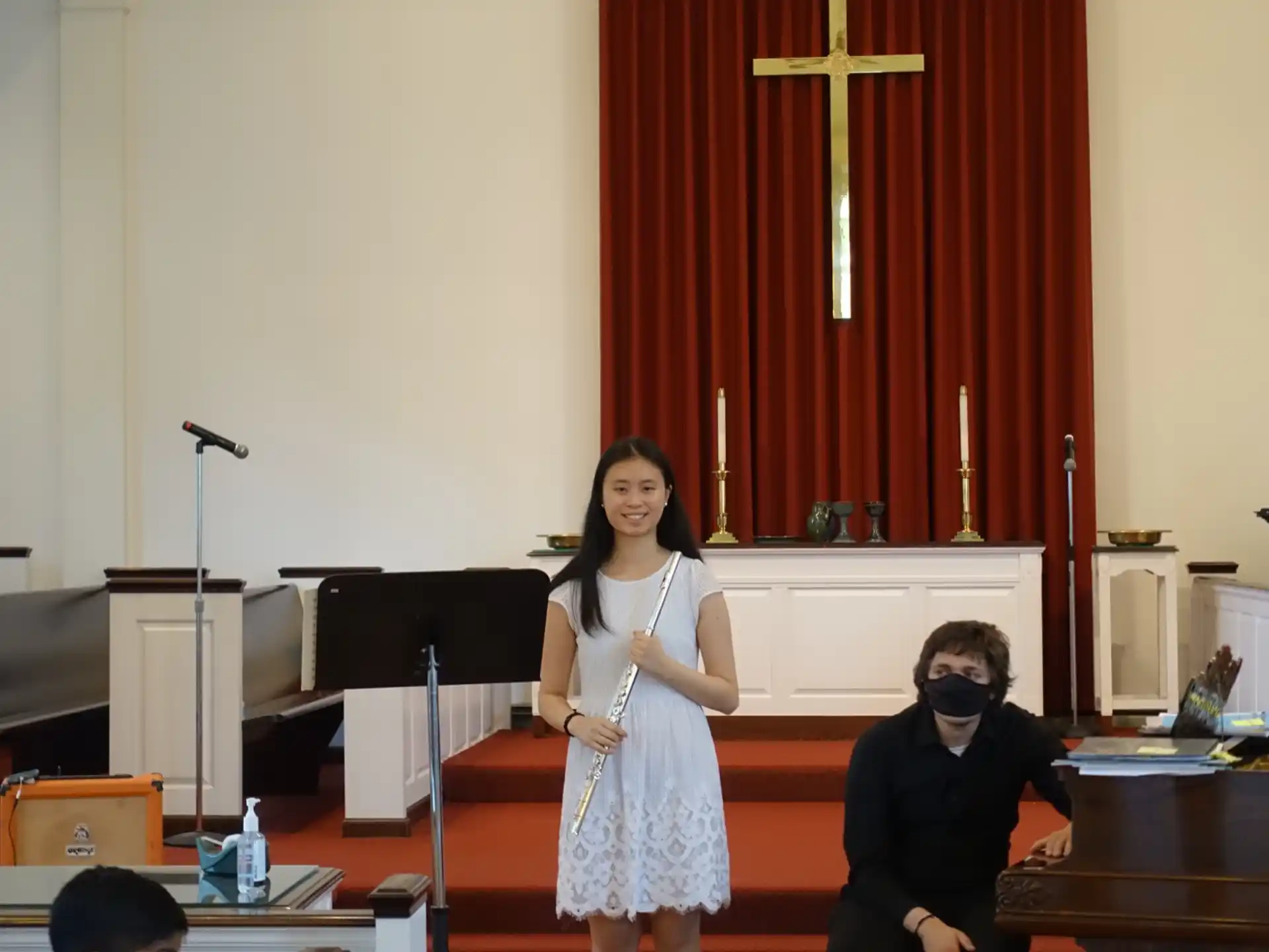 a woman standing in front of a podium with a man sitting at a desk with a microphone and
