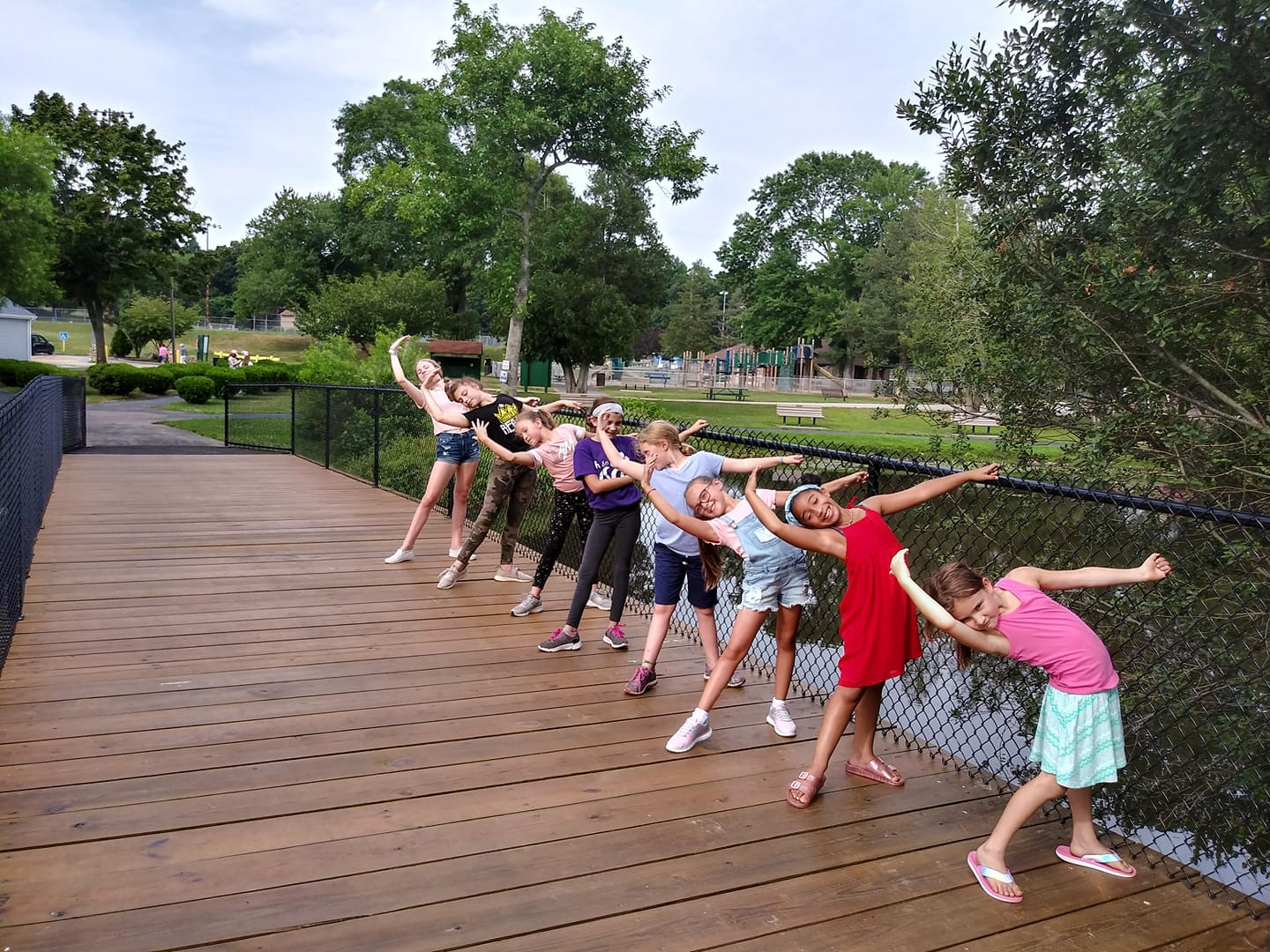 a group of people posing for a photo on a wooden deck