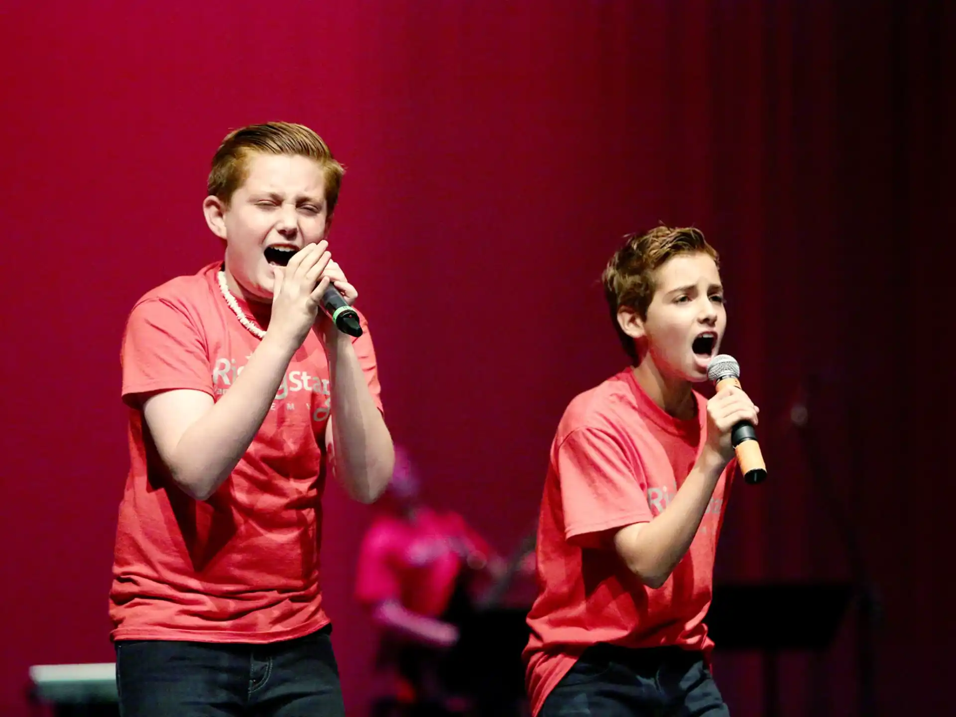a couple of men singing into microphones