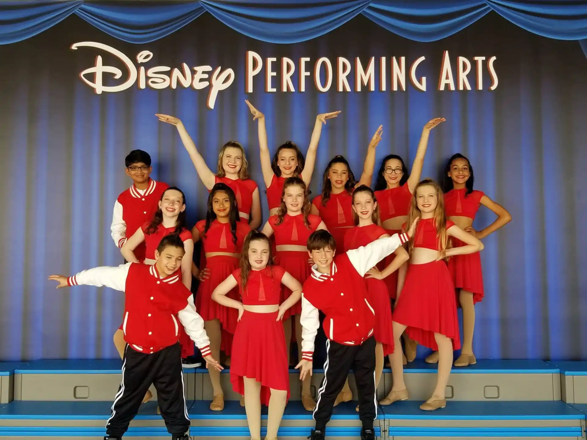 a group of people in red and white outfits on a stage