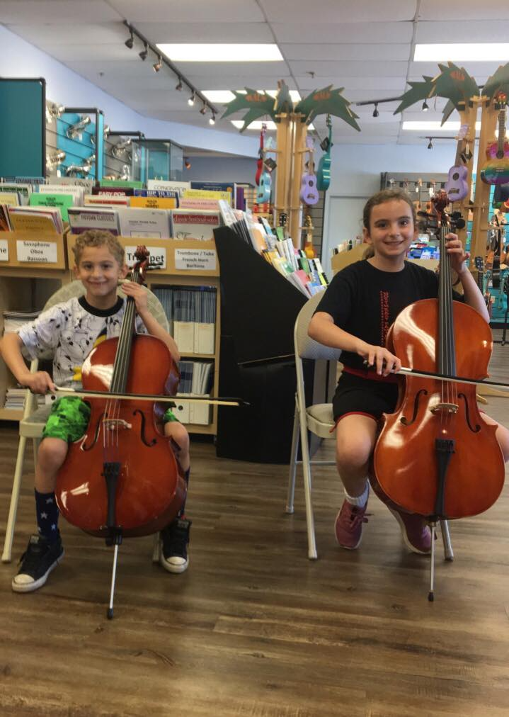 a couple of girls playing cellos