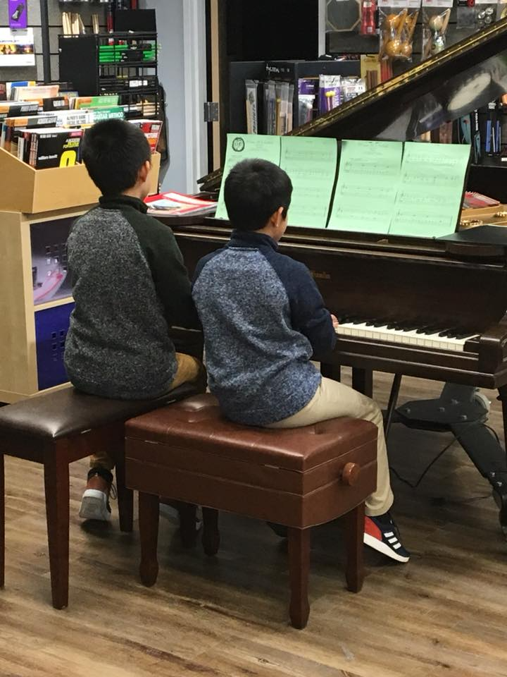 a couple of kids playing piano