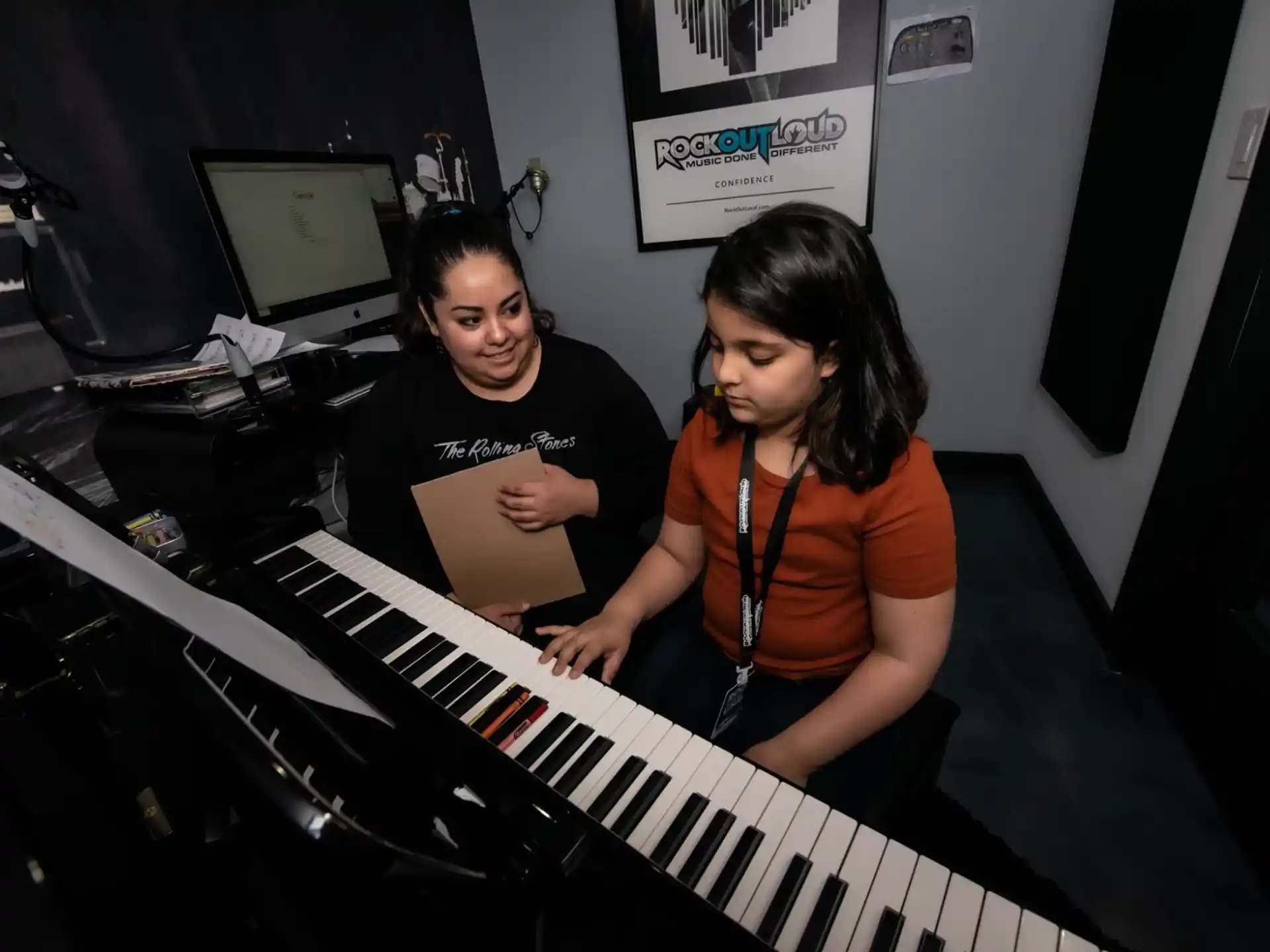 a couple of girls playing a piano