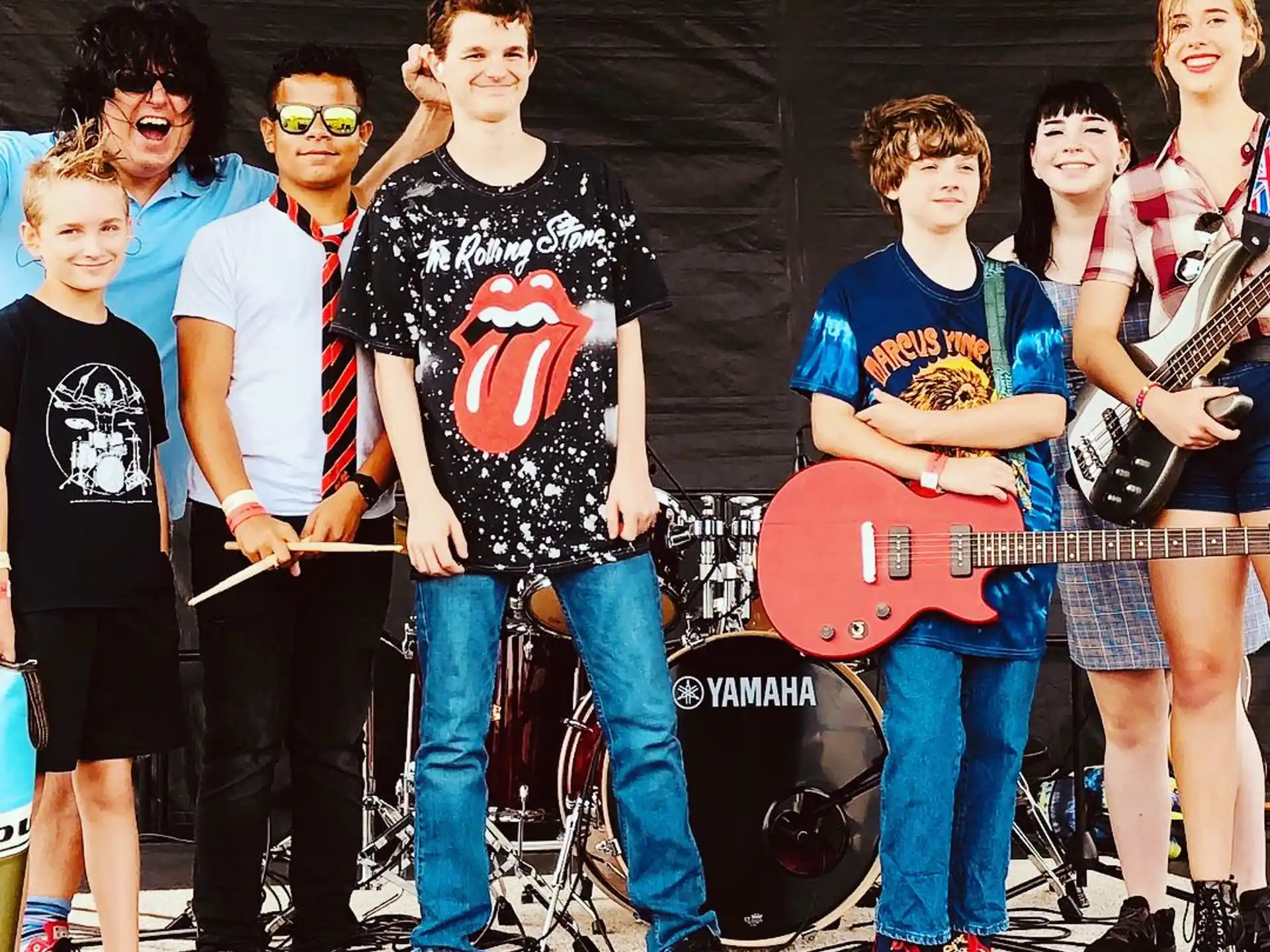a group of people posing for a photo with guitars