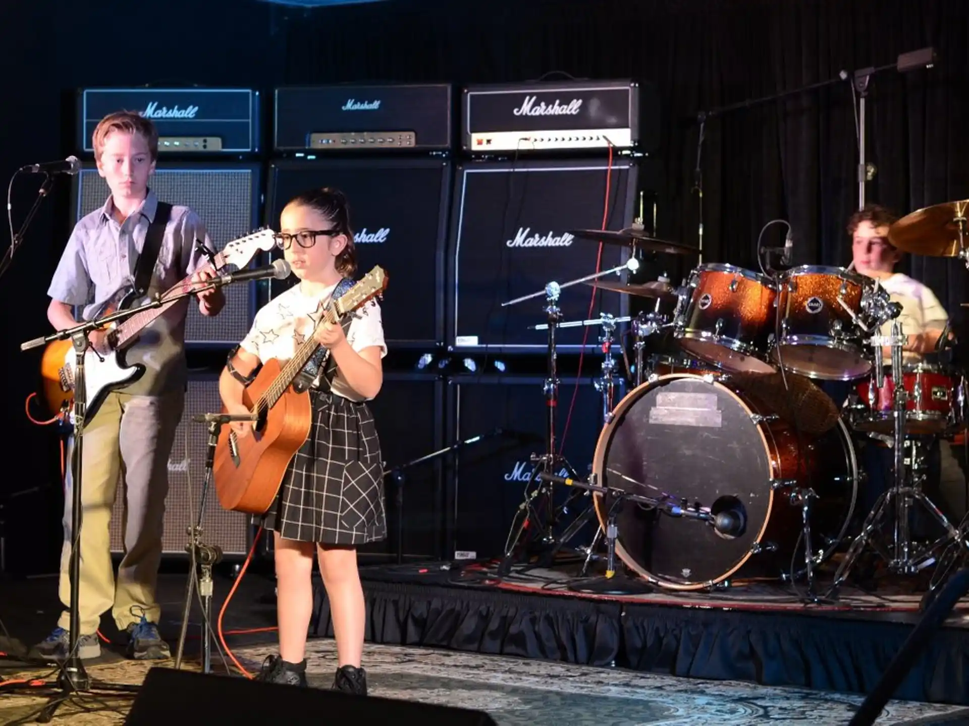 a group of people playing instruments on a stage